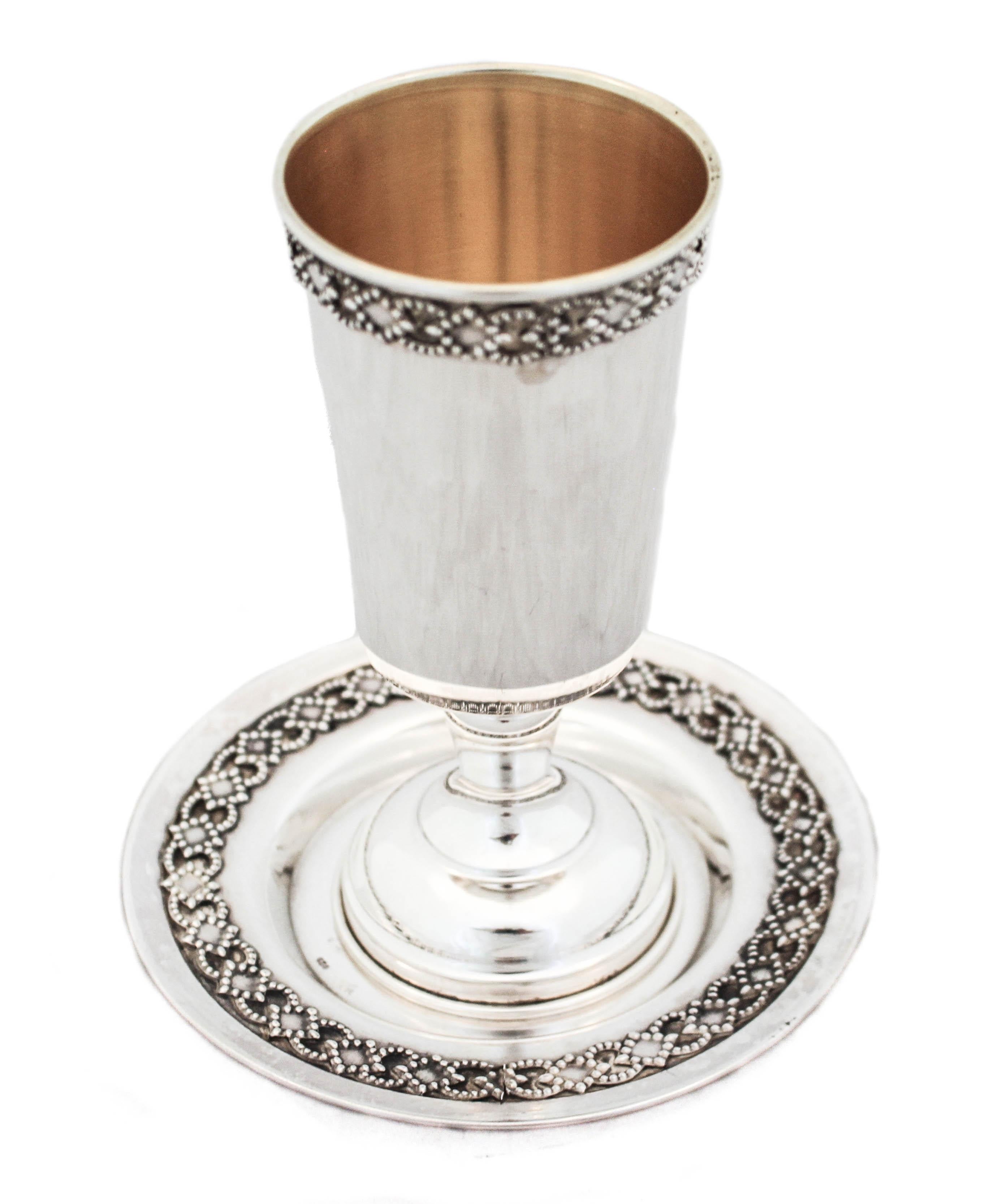 A sterling silver goblet and plate with just a decorative pattern around the top of the cup and the edge of the plate.  A diamond and circular design wraps around the rim of the cup and plate edge to give it just a little work.  A great gift for