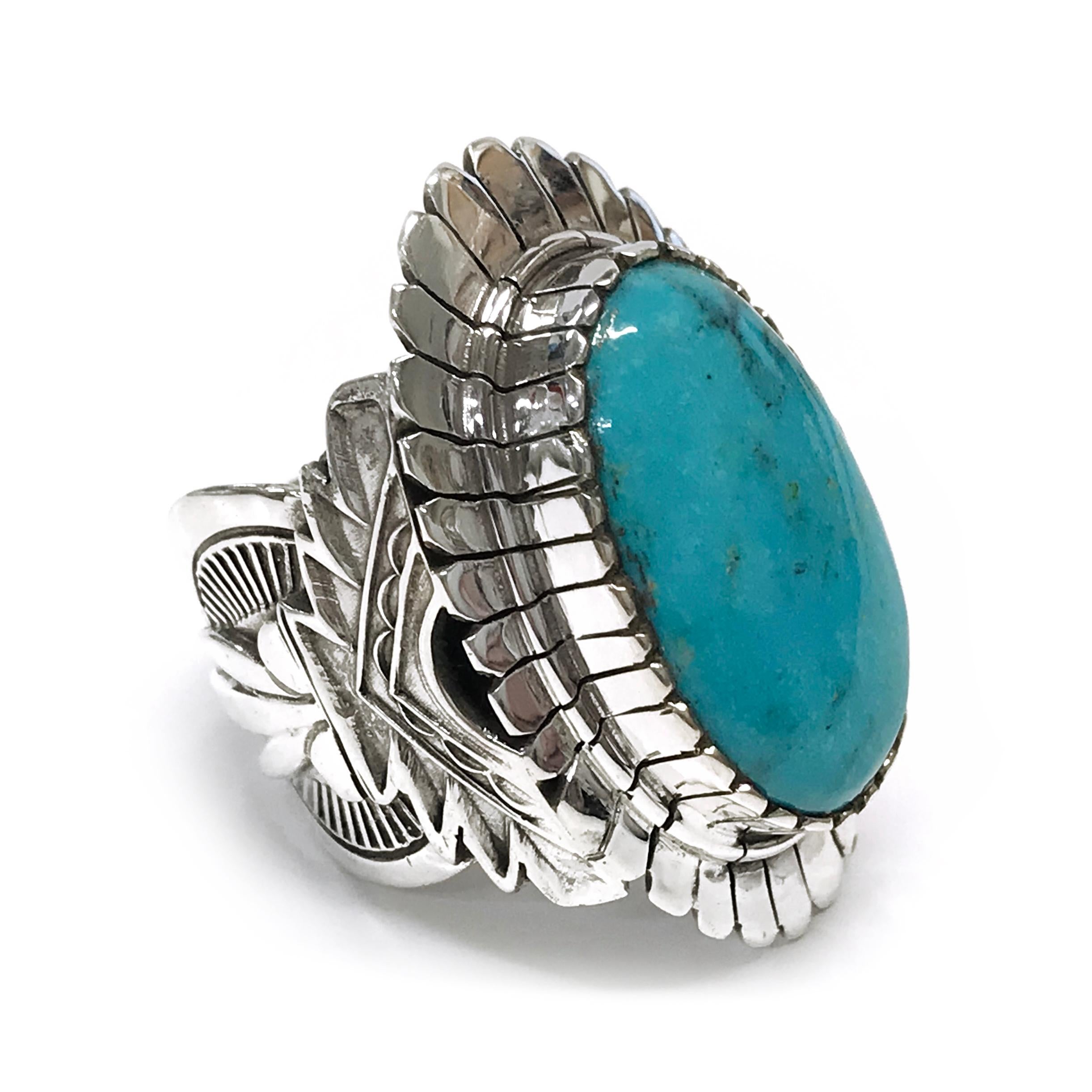 Handcrafted from sterling silver by jewelry maker, Ray Winner. This stunning ring features a large oval Kingman Turquoise cabochon set in a gorgeous wide Native American-inspired design band and bezel. The ring measures 36mm high x 24mm wide x