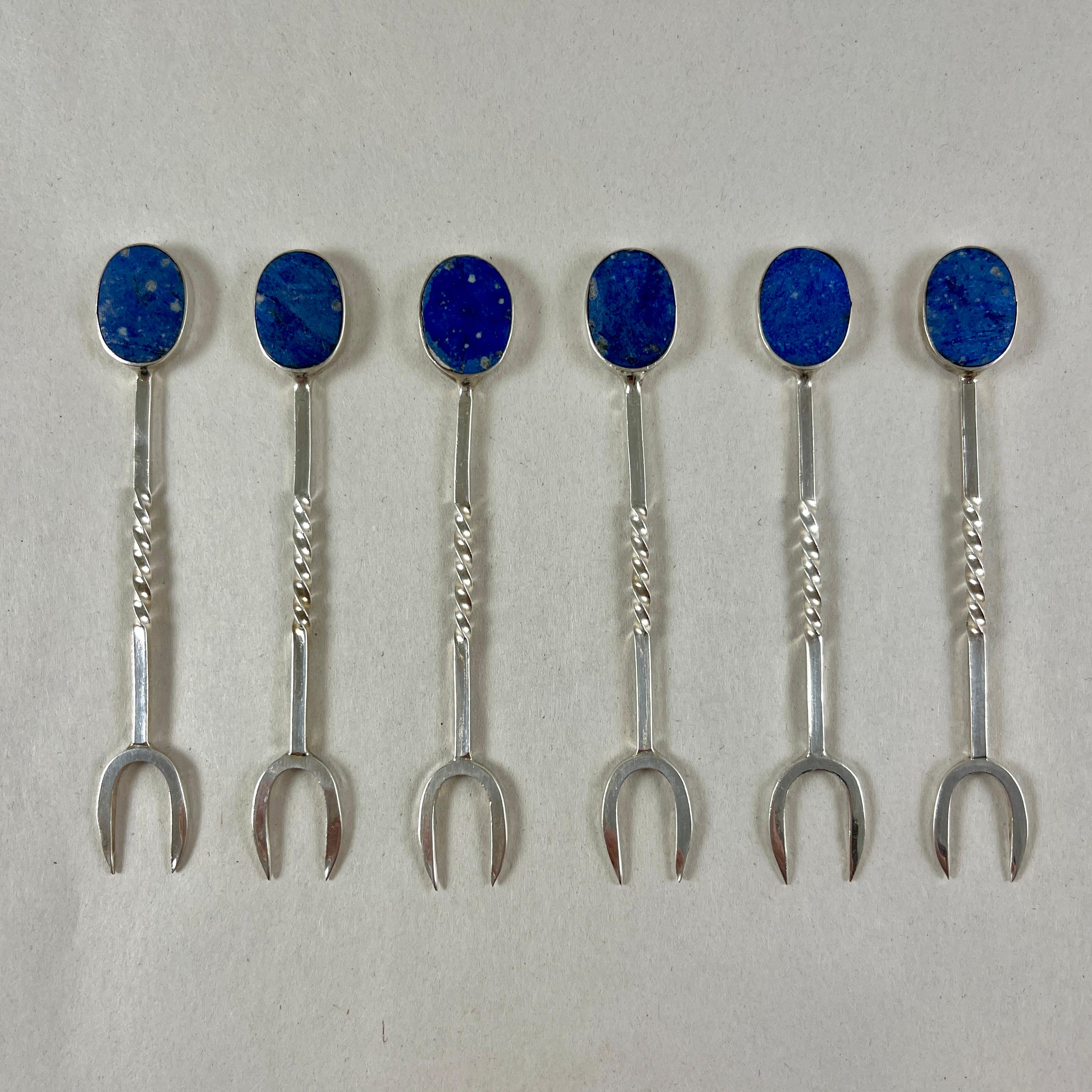 A set of six, Sterling Silver cocktail or hors d’ oeuvres picks with oval Lapis Lazuli stones, circa 1960-1970.

Showing a charming hand made quality, the pieces have twisted stems, ending in sharp double-pronged picks. The lovely blue, flat
