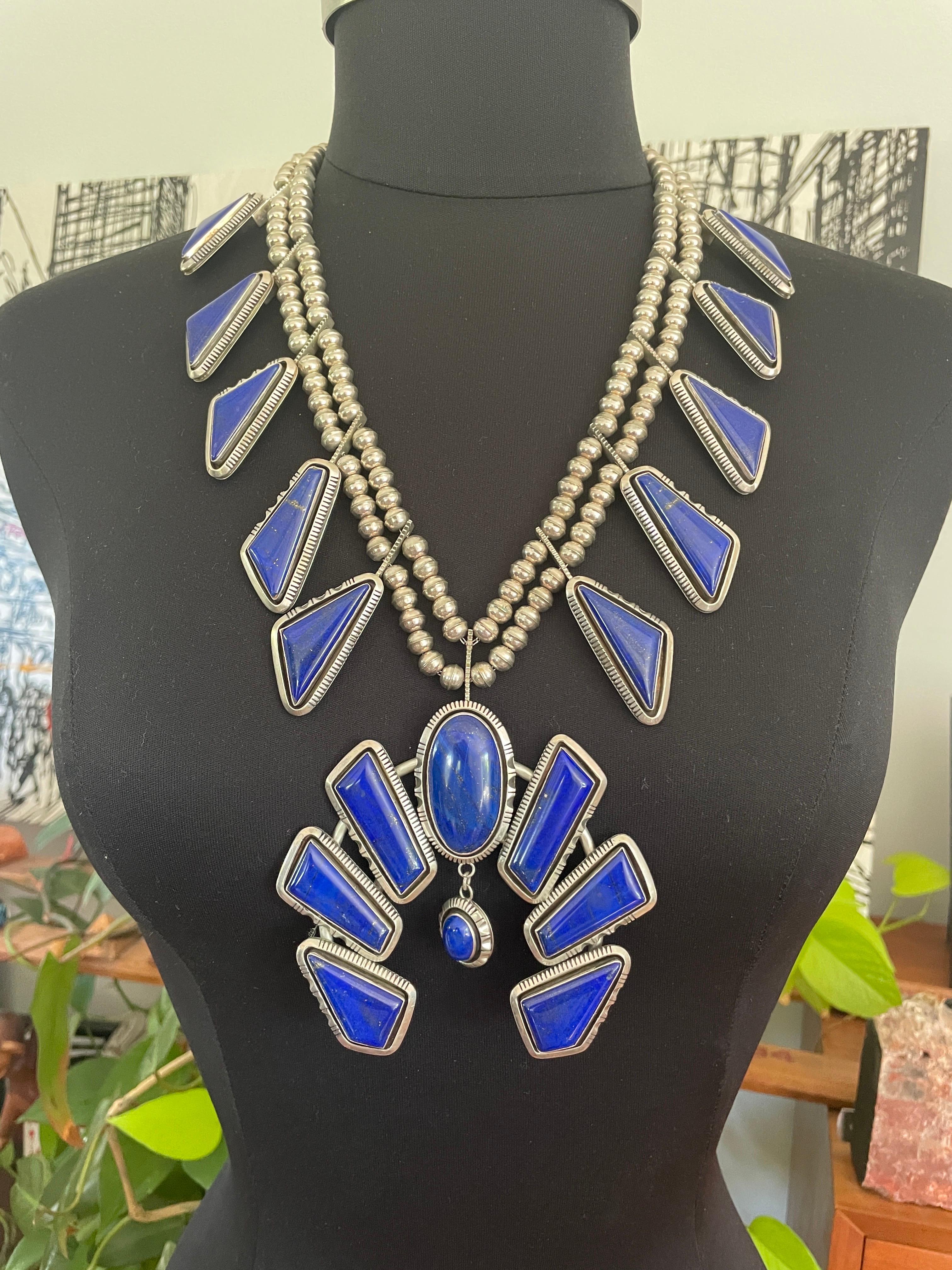 Voici un fabuleux collier Lapis Lazuli Navajo Squash Blossom. Il s'agit d'un grand collier.  Poinçonné au dos Mesure. Le Naja (goutte centrale) est de 3,90 pouces x 3,73 de haut en bas. Le collier double en perles de Sterling mesure 23 pouces d'un