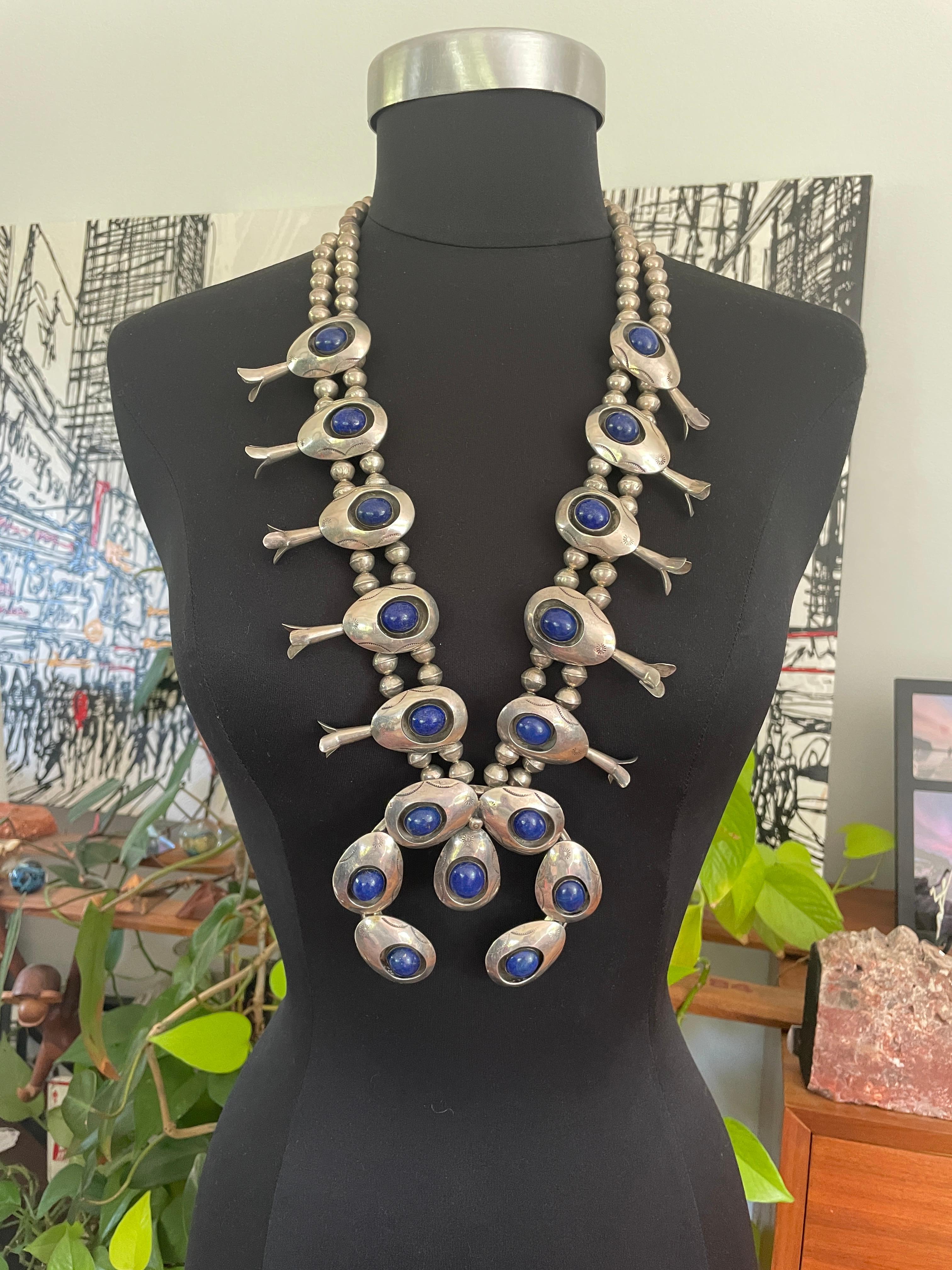 Questo è un fantastico pezzo di gioielleria Navajo! Shadow Box Squash Blossom in Lapislazzuli. 10 pietre di Lapis incastonate in fiori di sterling attaccati a una catena di sterling a doppia perlina. Si gradua in un unico filo più vicino alla