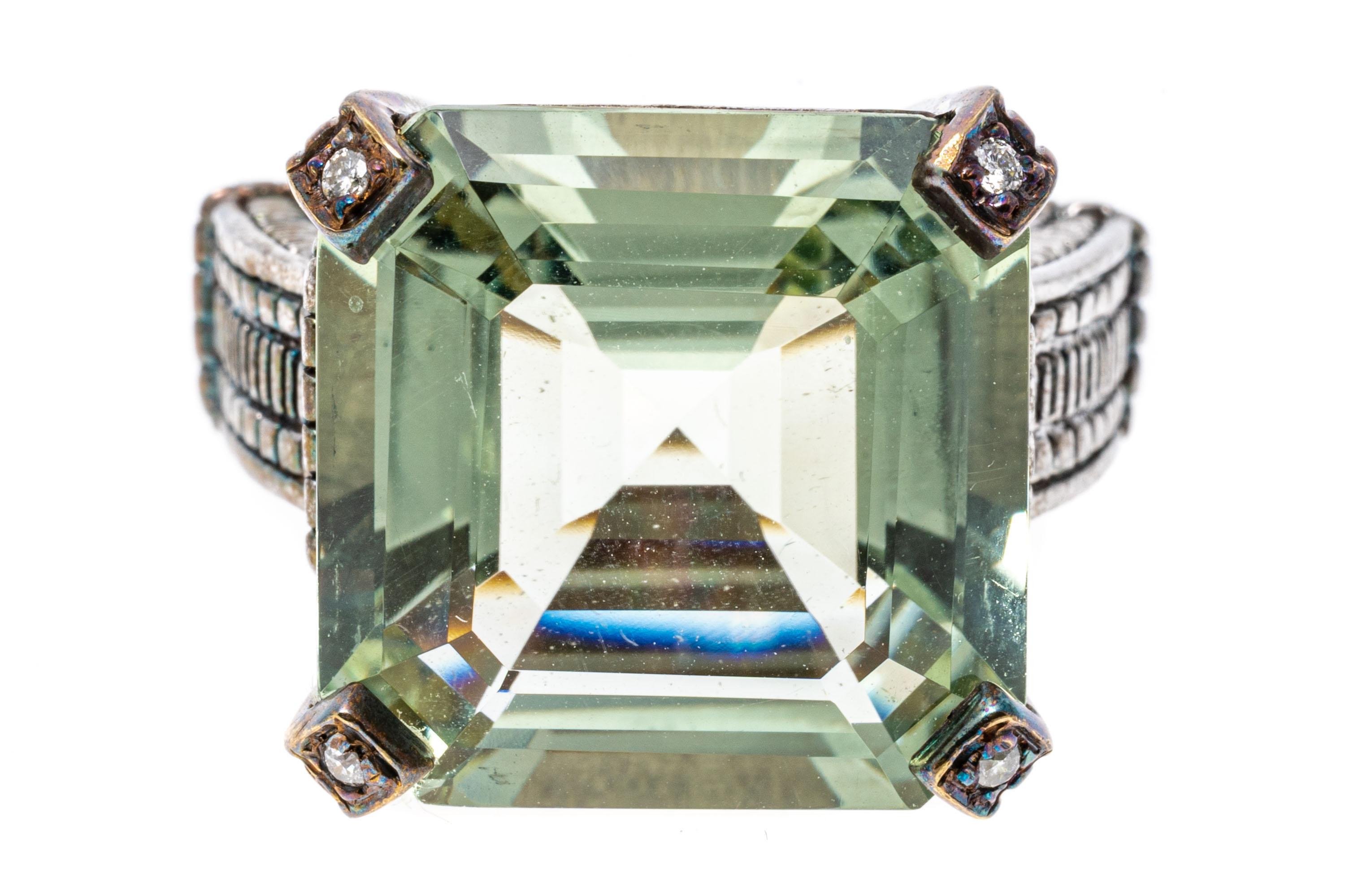 Sterling silver and gold ring. This interesting patterned sterling silver ring features a square faceted, pale green color center prasiolite, approximately 14.06 CTS, decorated with round faceted, diamond set prongs, approximately 0.02 TCW.
Marks: