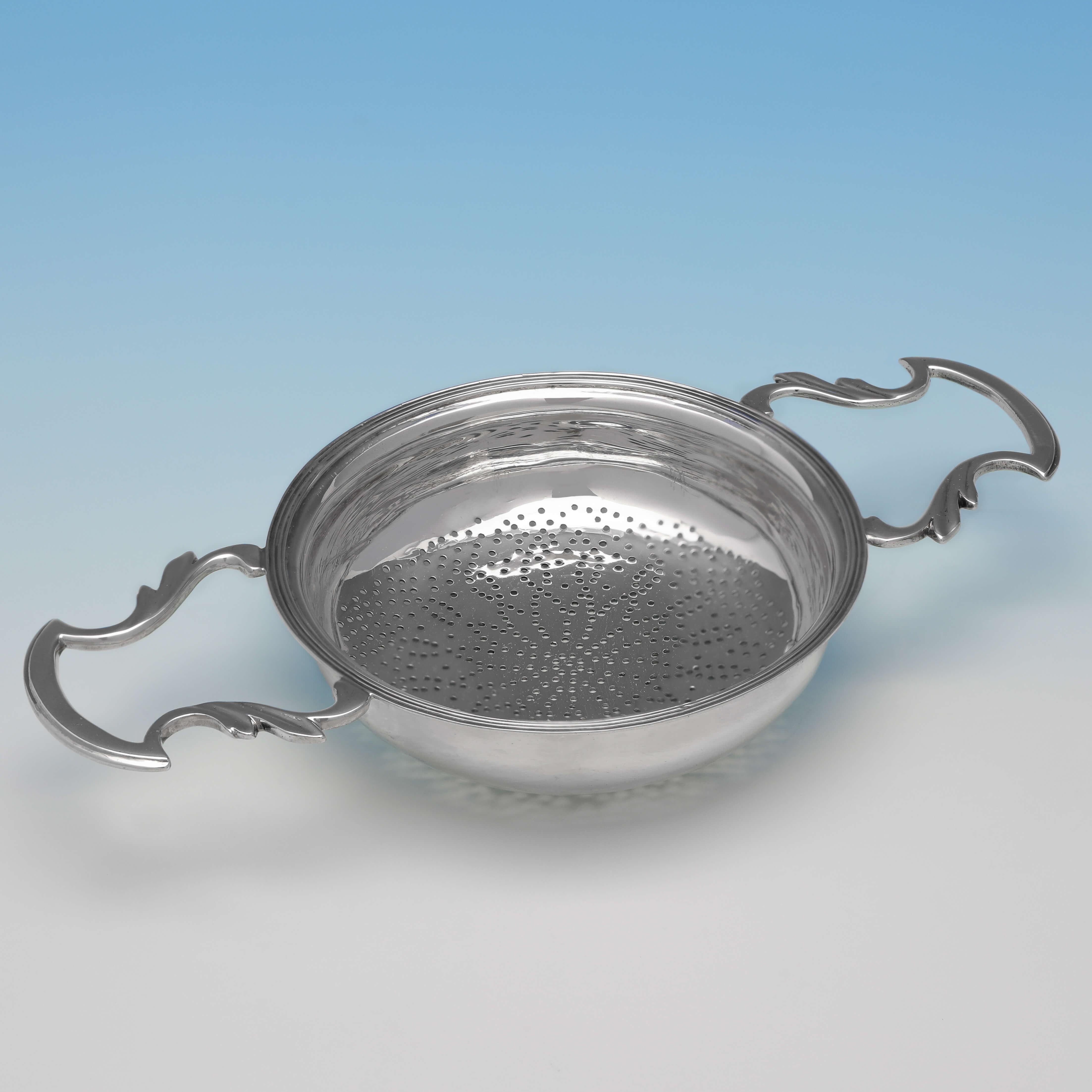 Hallmarked in London in 1922 by Goldsmiths & Silversmiths Co., this handsome, sterling silver lemon strainer, is in the style of a George II example. The lemon strainer measures 1.25