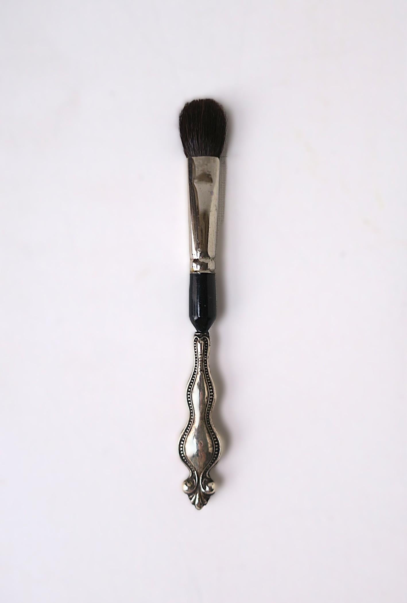A makeup brush (real hair) with sterling silver handle. Brush has never been used. Marked 'Sterling' on handle as shown in last image. A great piece for a curated vanity area. 