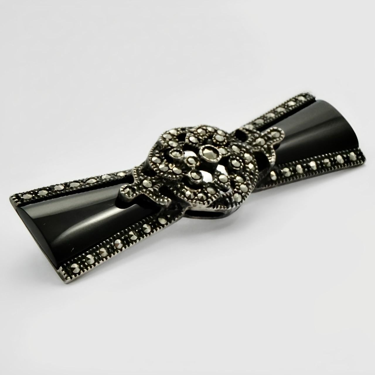 Beautiful sterling silver and black glass Art Deco style brooch with a flower design. It is set with marcasites and has a black enamel finish. Measuring length 5 cm / 1.9 inches by width 1.5 cm / .5 inch.

This is a stylish silver brooch with black