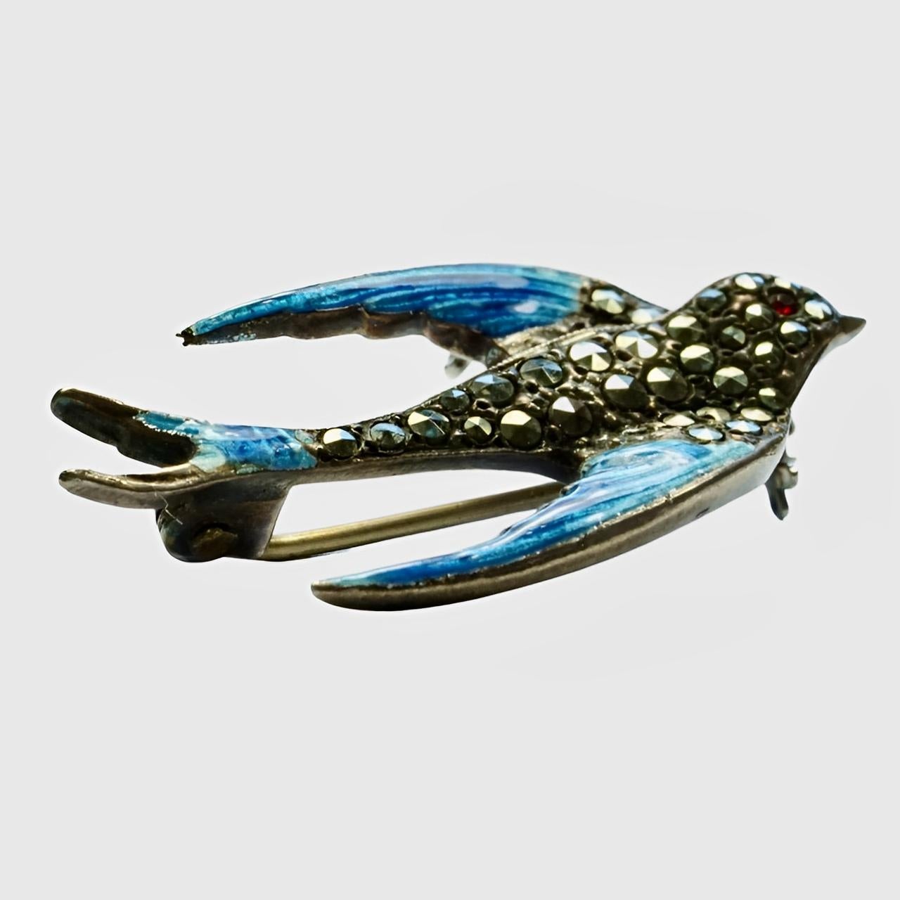 Schöne Sterling Silber Schwalbe Vogel Brosche mit einem roten Auge. Sie ist mit Markasiten besetzt und mit blauer Emaille verziert. Länge 3,4 cm / 1,3 Zoll und Breite 1,8 cm / .7 Zoll.

Dies ist eine sehr schöne silberne Schwalbenbrosche mit