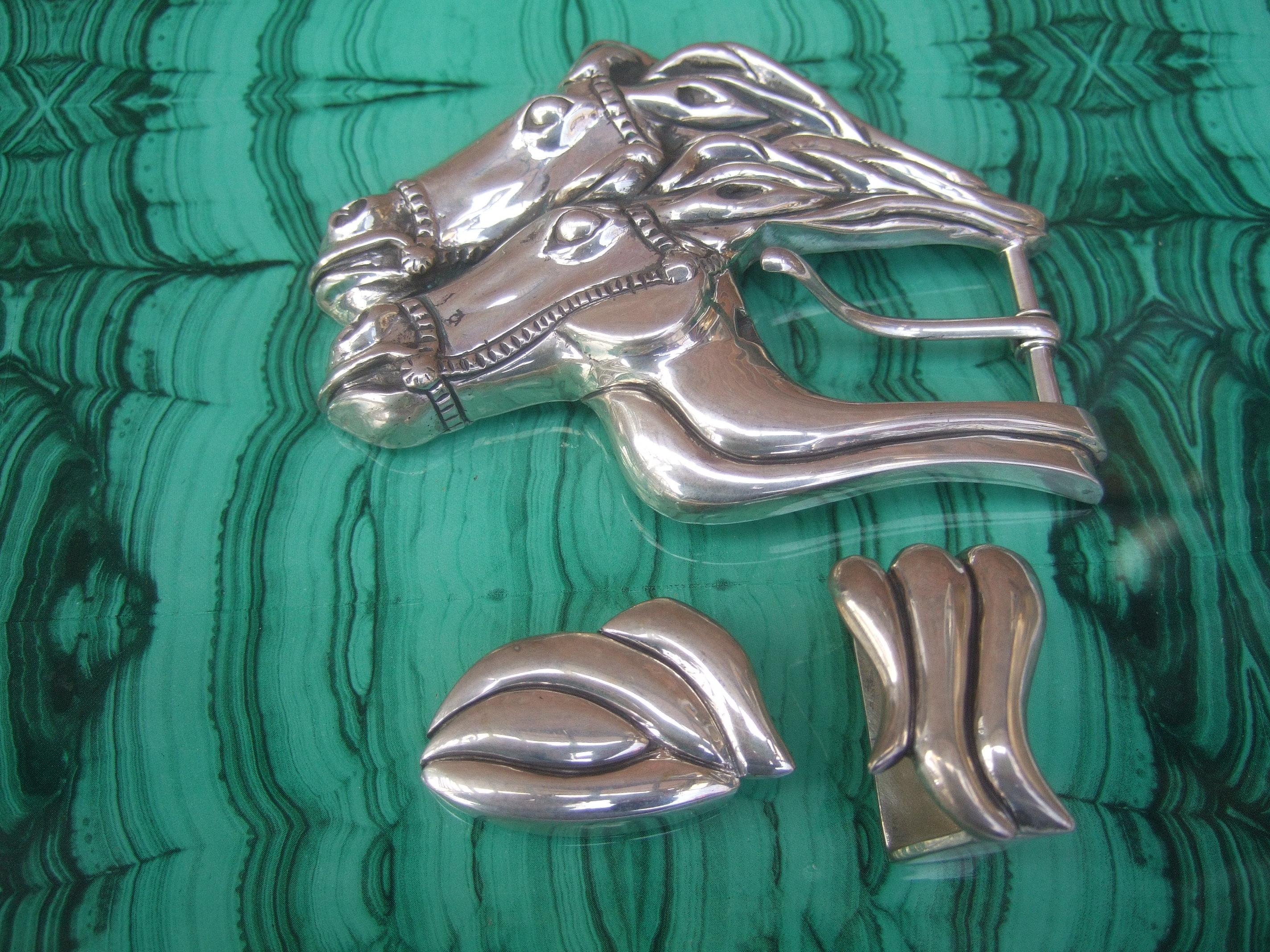 Sterling silver massive equine belt buckle designed by Kokopelli 
The ornate belt buckle is designed with a stylized pair of sterling
silver horse heads

The large scale artisan belt buckle makes a very striking accessory 
Paired with a set of