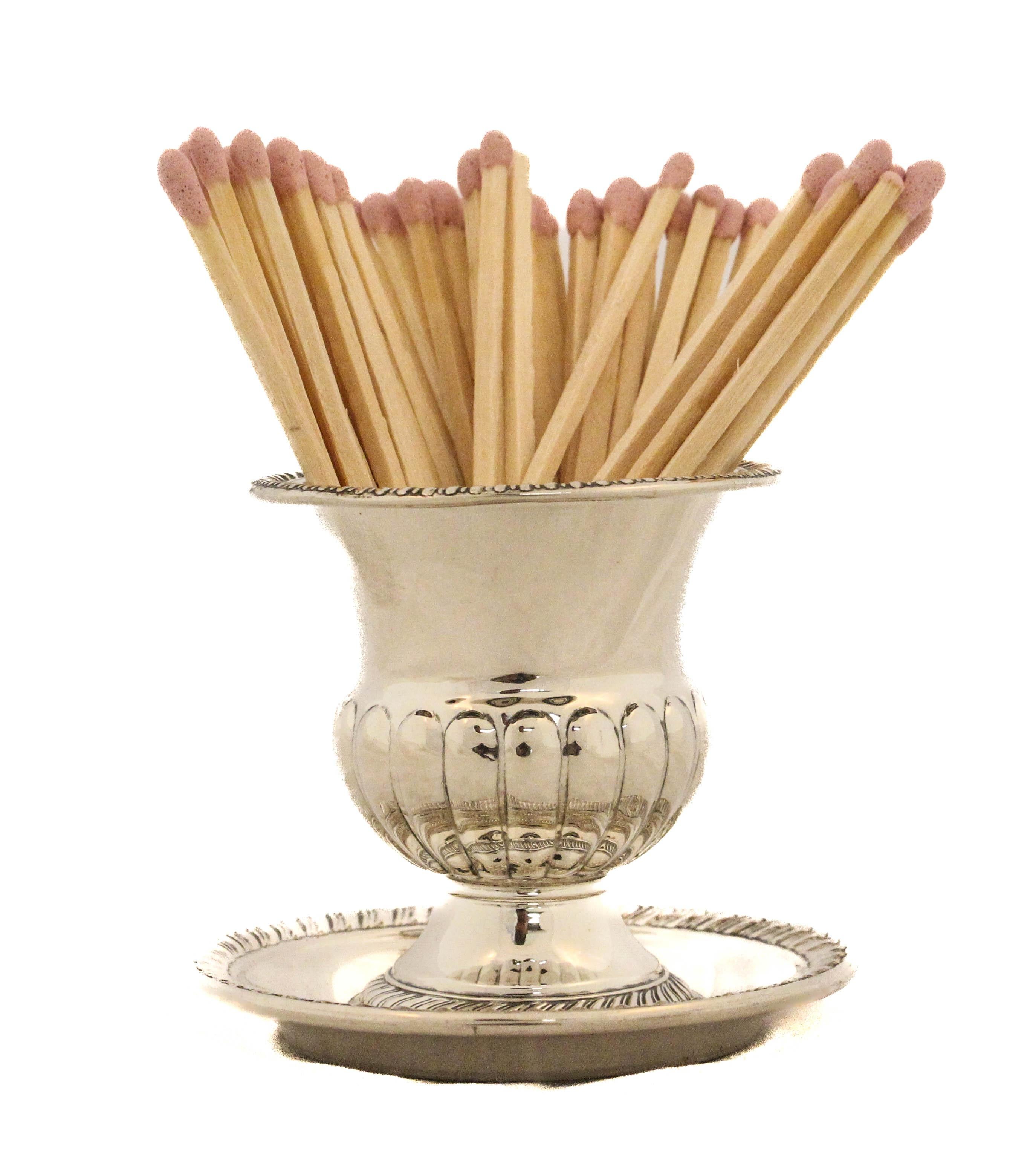 This elegant sterling silver urn and coordinating underplate offer a refined and functional accent for any classic interior. Standing at 3 inches tall, the urn is perfectly sized for holding wooden matches, with an aesthetic presence that belies its
