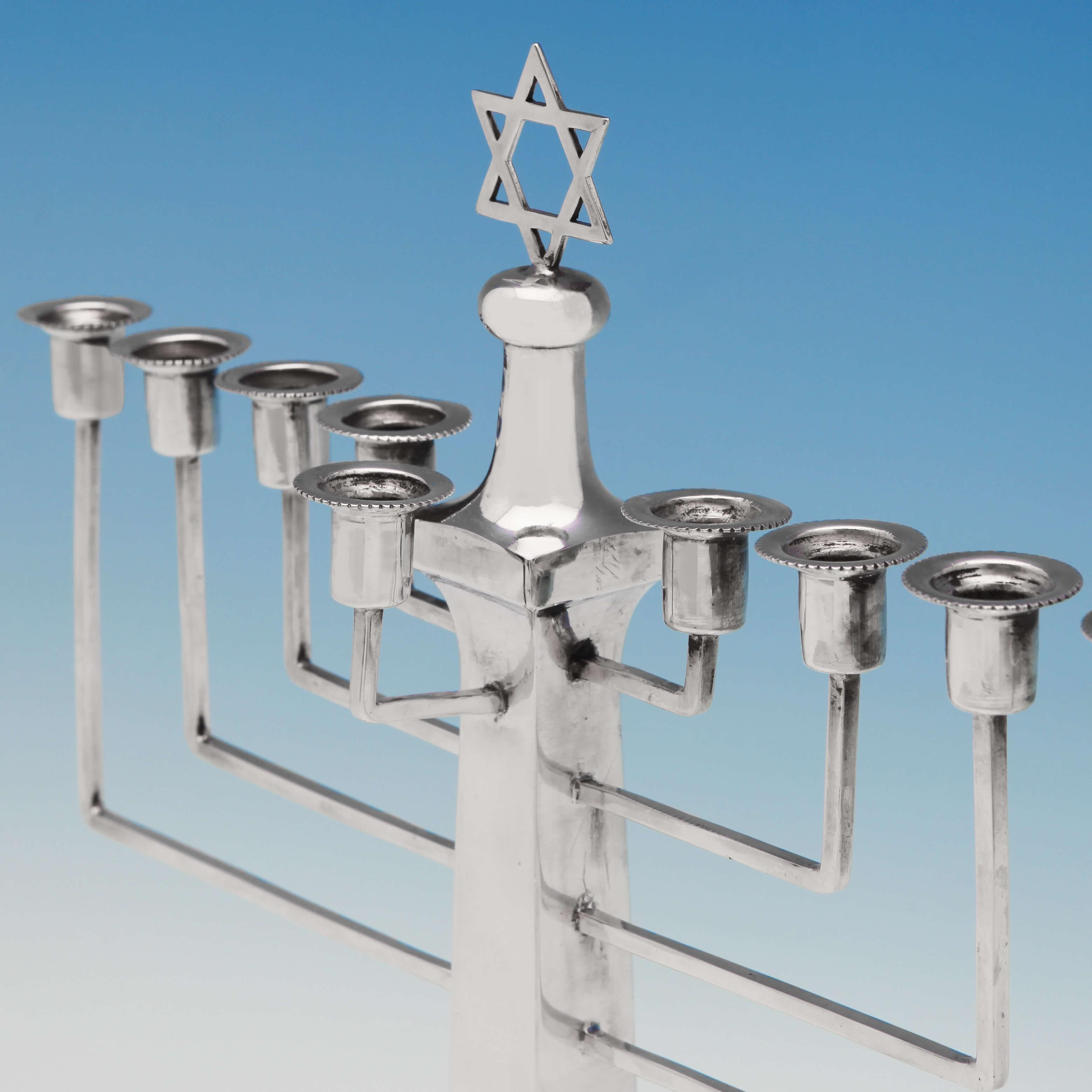 Hallmarked in Birmingham in 1931 by Britton, Gould & Co. This classic, George V, Sterling Silver Menorah, or Chanukiah, stands on a stepped square base with a bead border, the tapered column terminating with a Star of David finial. The menorah