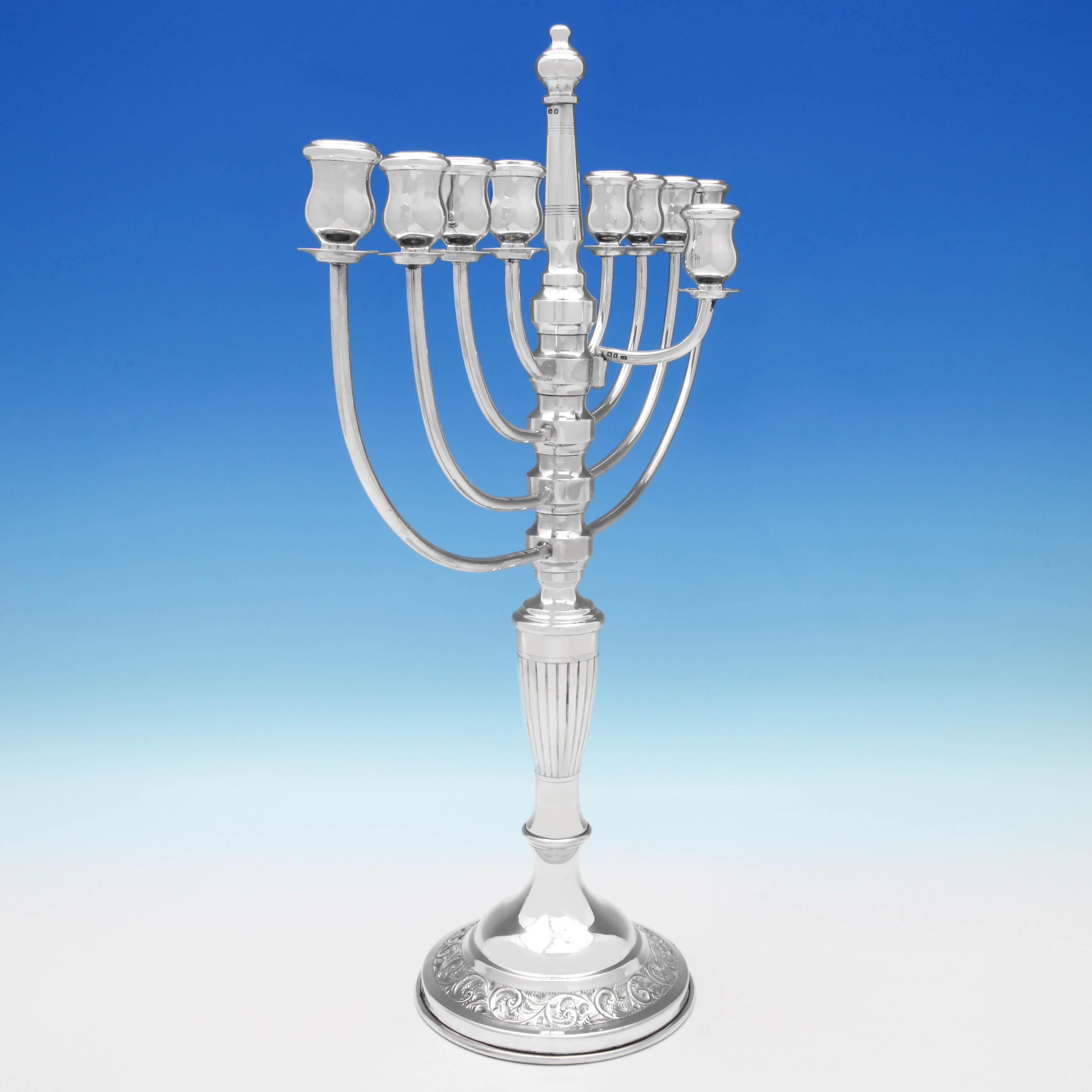 Hallmarked in London in 1921 by Joseph Zweig, this striking, large, George V, Sterling Silver Menorah, features a fluted column, with two bands of reed decoration at the top, plain loop branches and acanthus detailing to the base. The menorah