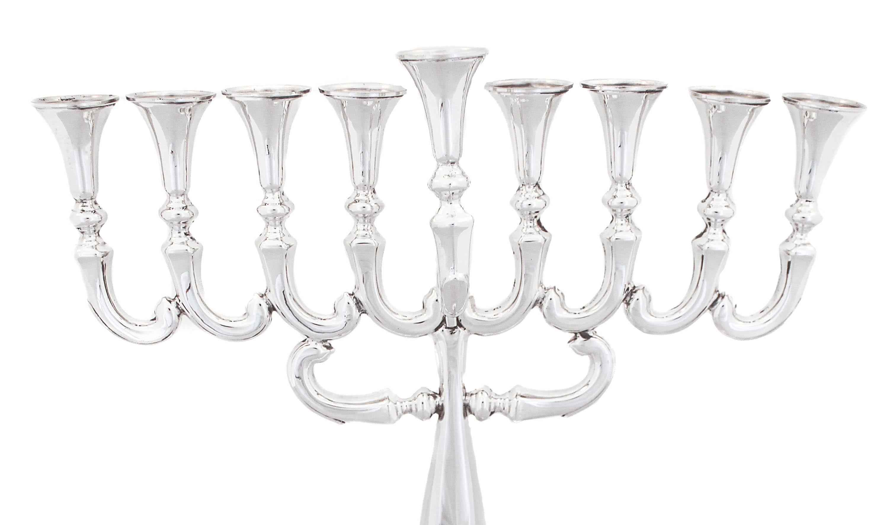 Being offered is a sterling silver menorah made in Israel.  It has a sleek and modern look with a more traditional shape.  The pedestal has a marquee shape while the arms (branches) connect to each other in a curved shape design.  The shamash is