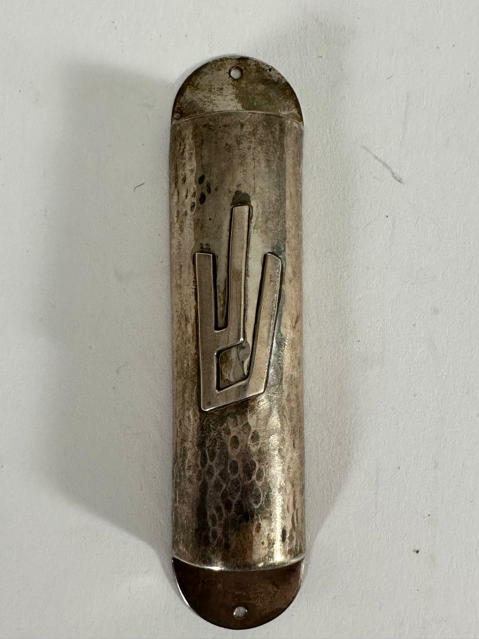 This beautifully handcrafted sterling silver mezuzah case was made in Jerusalem in 1950 by the Israeli silversmith Isaac Bier, a known artisan associated with the Bezalel School of Arts and Crafts. The piece is marked on the reverse 