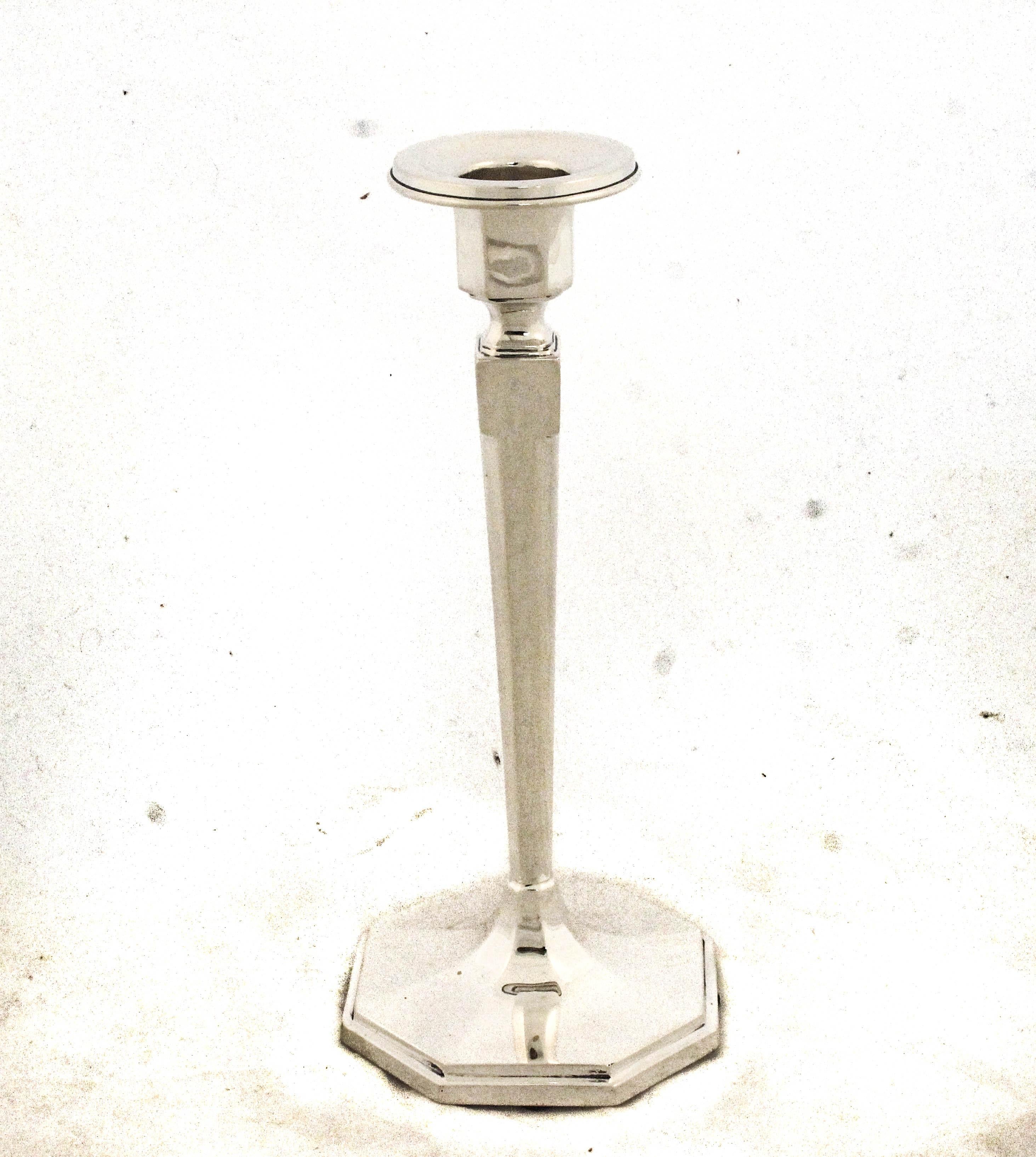 Te ofrecemos un llamativo par de candelabros de plata de ley fabricados por la renombrada William B. Durgin Company, famosa por su fina orfebrería americana. Estos candelabros encarnan la limpia elegancia del diseño moderno de mediados de siglo,