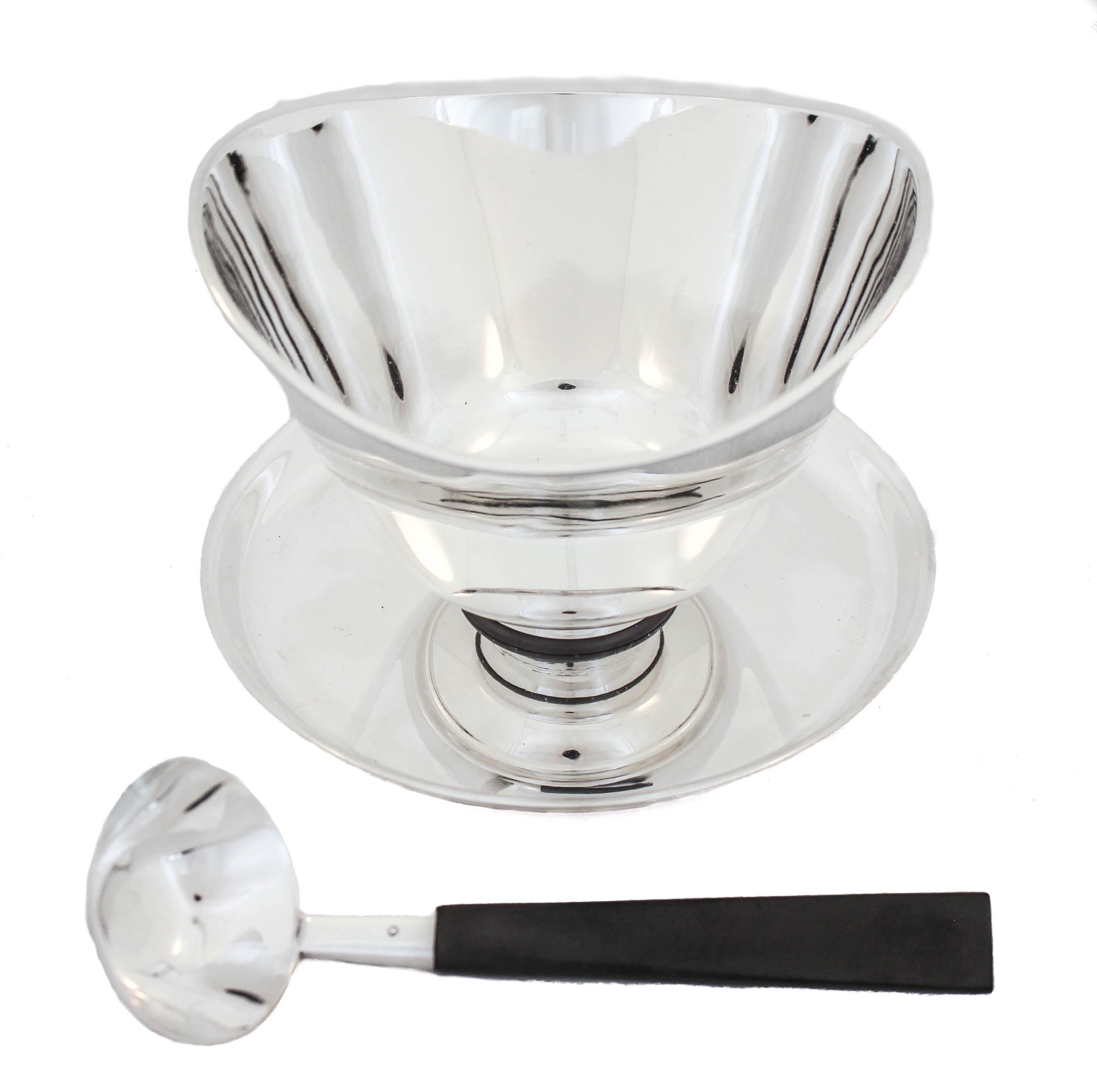 Being offered is a sterling silver sauce bowl with an attached under-tray and original ladle.  Made in Denmark in the 1950’s it has a quintessential Mid-Century simplicity and sleekness to it.  The form is modern and yet classic in that Scandinavian