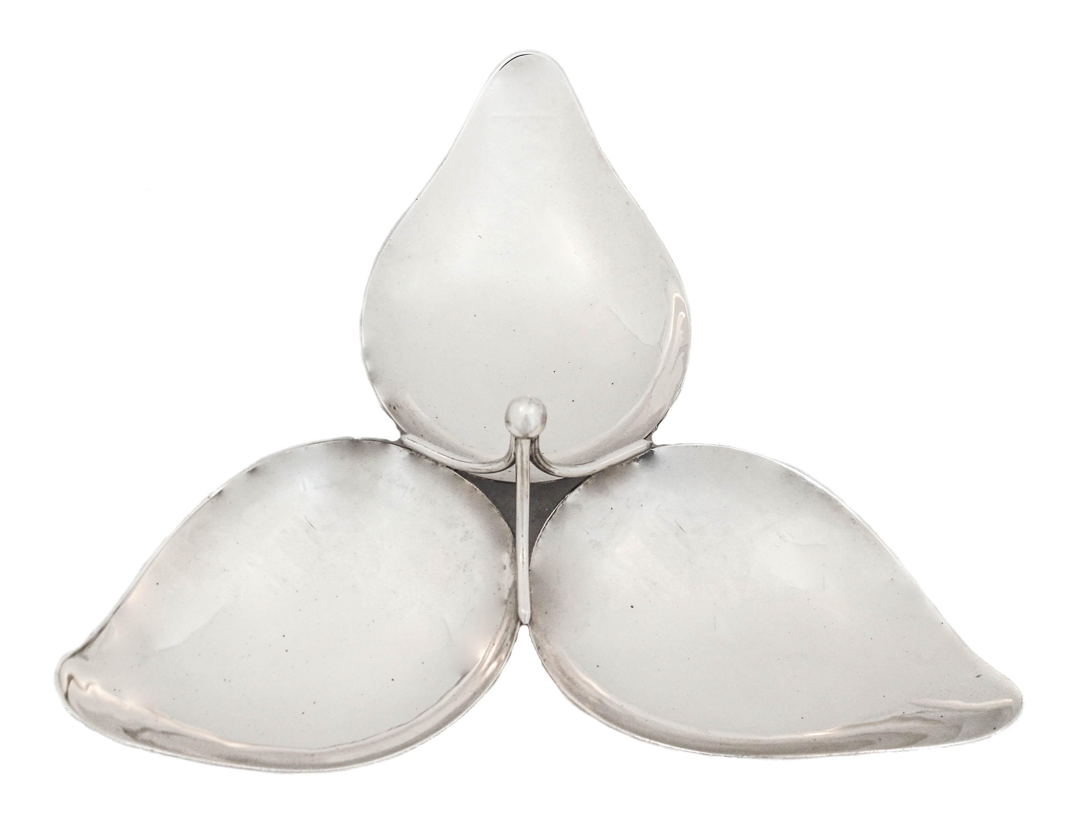 Being offered is a sterling silver Mid-Century modern sectional.  Each of the three sections is shaped like a leaf and curves upwards.  In the center a simple handle connects all three together with a ball finial.  Each section is big so it can hold