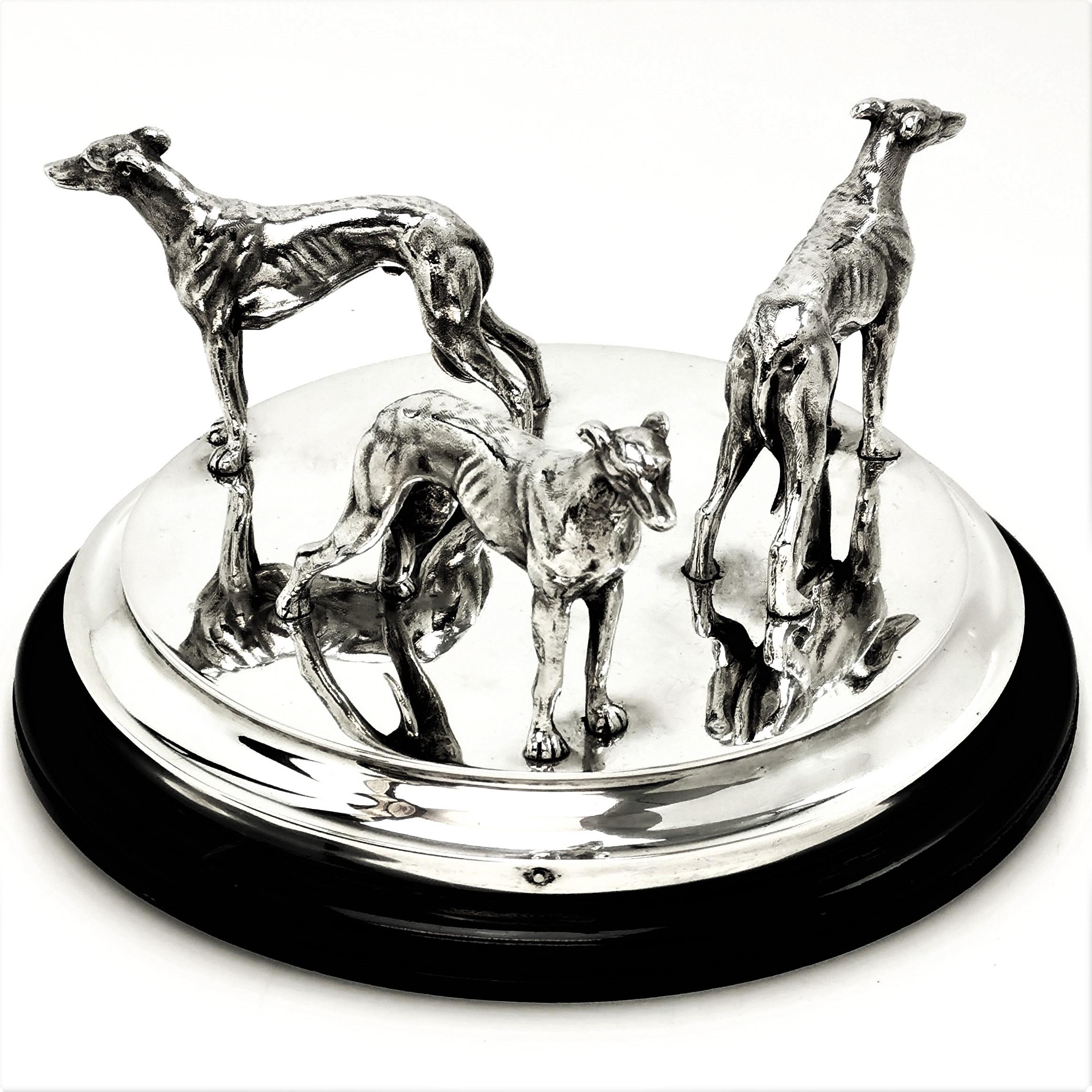 A gorgeous vintage solid Silver Model of three Greyhounds standing on a circular silver base on a black circular plinth. Each Greyhound Faces outward in different directions making a lovely sculpture from any angle.

Made in London in 1837 by