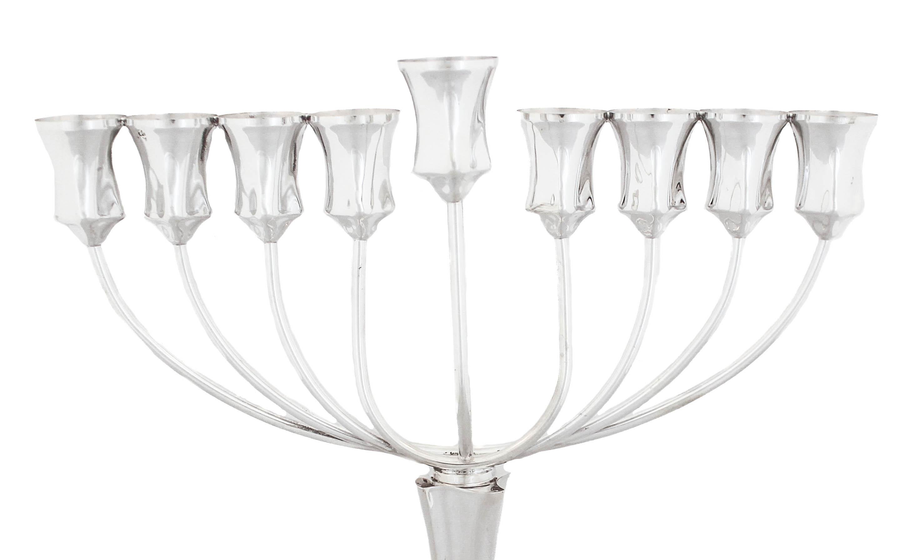 Being offered is a new sterling silver menorah made in Israel.  It has a shiny finish with a swirl base and square shape cups.  It is contemporary and sleek.  The menorah unscrews in the center — where the pedestal meets the top for easy storage.  A