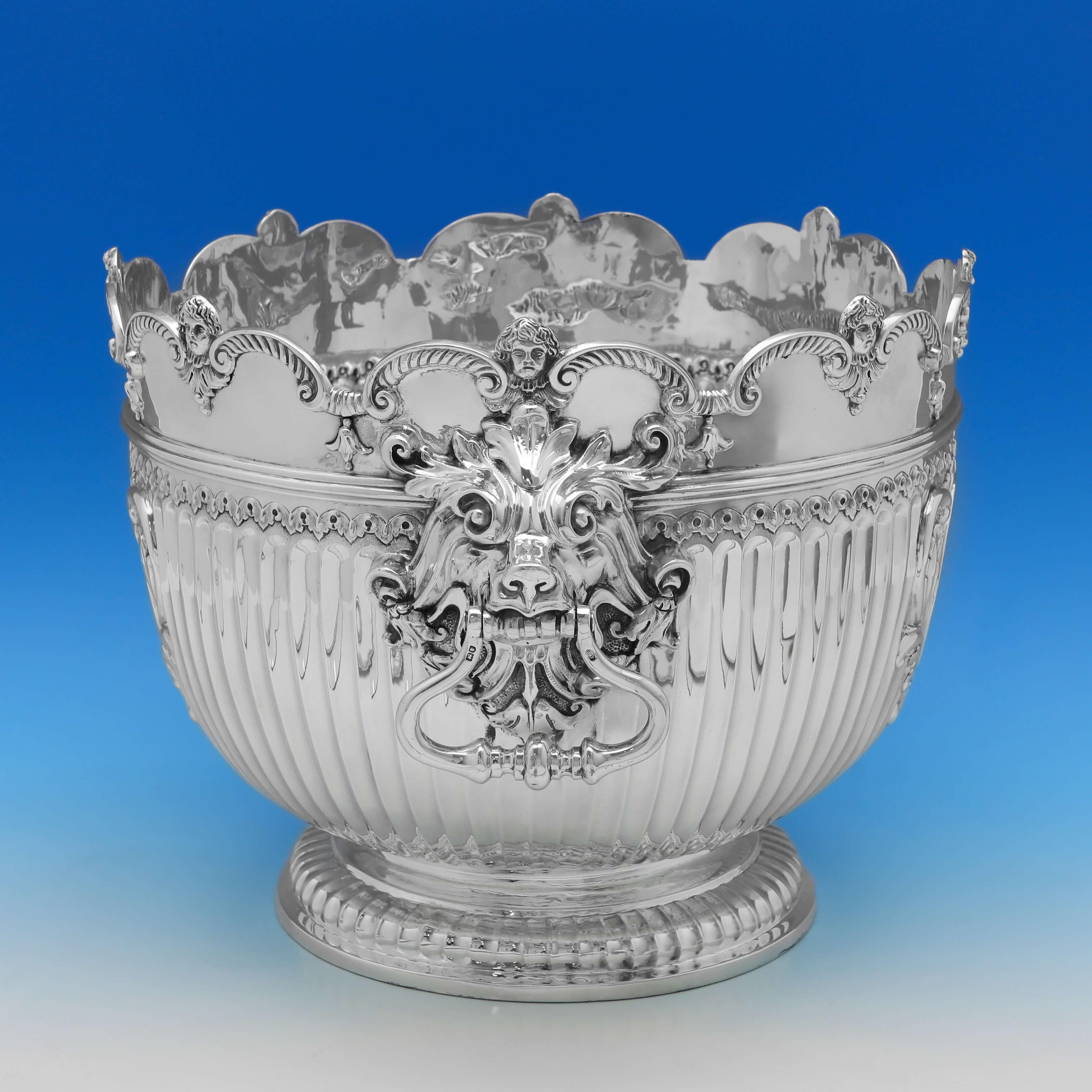 Hallmarked in London in 1904 by Carrington & Co., this handsome, Edwardian, antique sterling silver bowl, is in the 'Monteith' style, with lion mask drop rings handles, sunken fluting and s shaped rim. The bowl measures 11.25