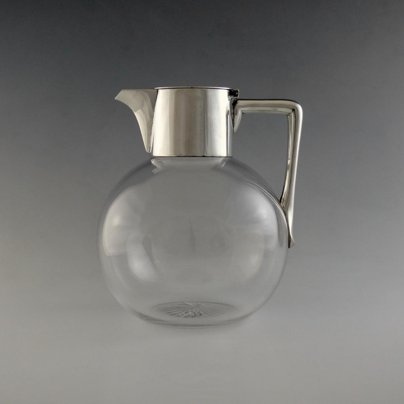 An elegant silver mounted glass claret jug with star cut base and silver top with handle, hallmarked London 1892; by Hukin and Heath. Deceptive in that, although modest looking in size, it holds exactly one bottle.

Dimensions: 12 cm/4¾ inches