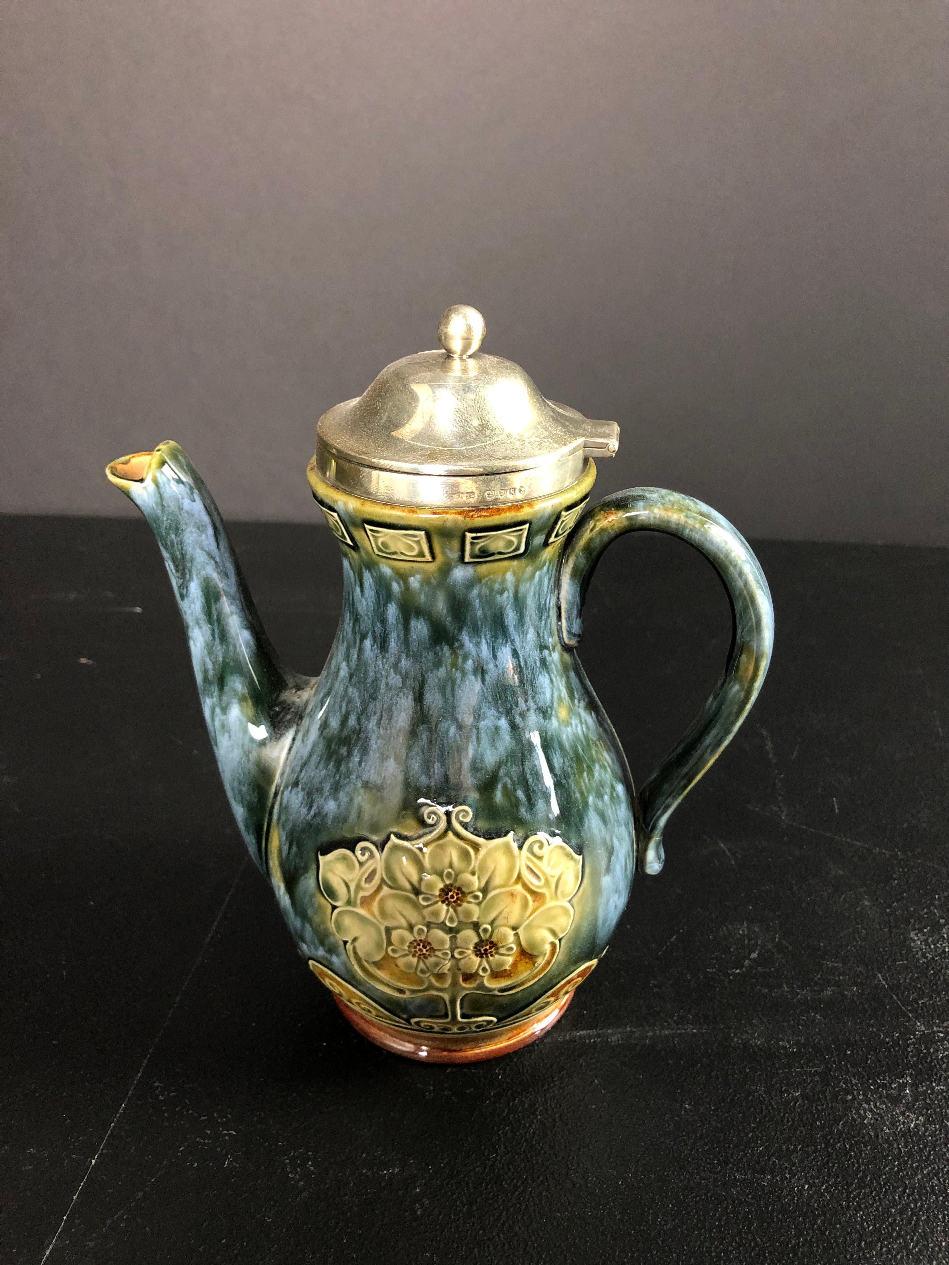 Art Nouveau sterling silver mounted and fully hallmarked Royal Doulton blue glazed lidded pitcher. 19th century petite pitcher with raised Art Nouveau design.
  