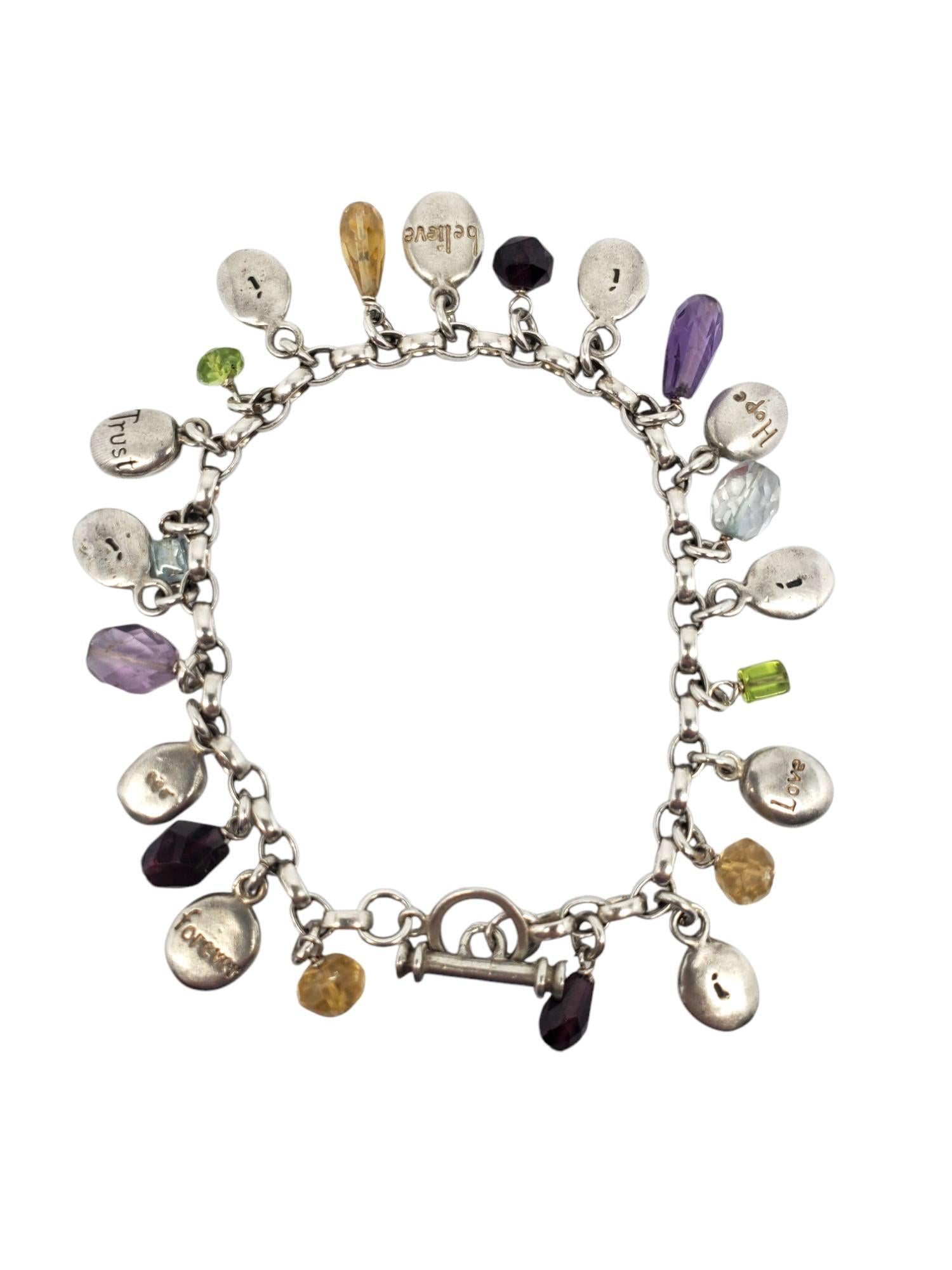 Bracciale con charme in argento sterling e pietre multiple - A. Silver

Questo braccialetto con ciondoli con parole d'ispirazione presenta pietre multicolori e targhette ovali incise con Love, Hope, Believe, Trust, Learn, Forever in argento sterling