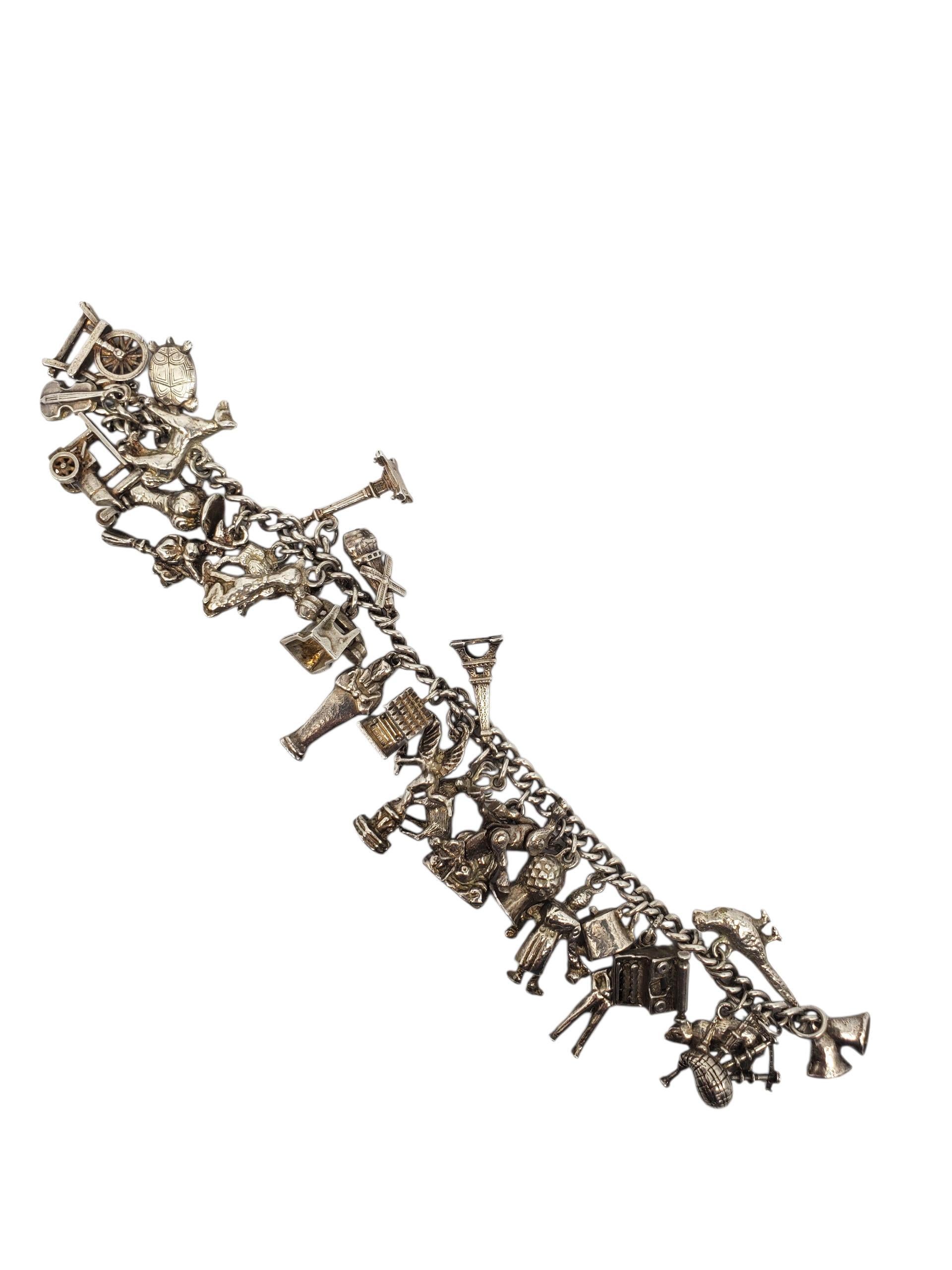 Bracciale con charme multiplo in argento 925 - A. Silver

Questo impressionante braccialetto di charme vintage in argento sterling presenta oltre 28 dettagliati charme 3D che includono punti di riferimento, animali, strumenti musicali e molto