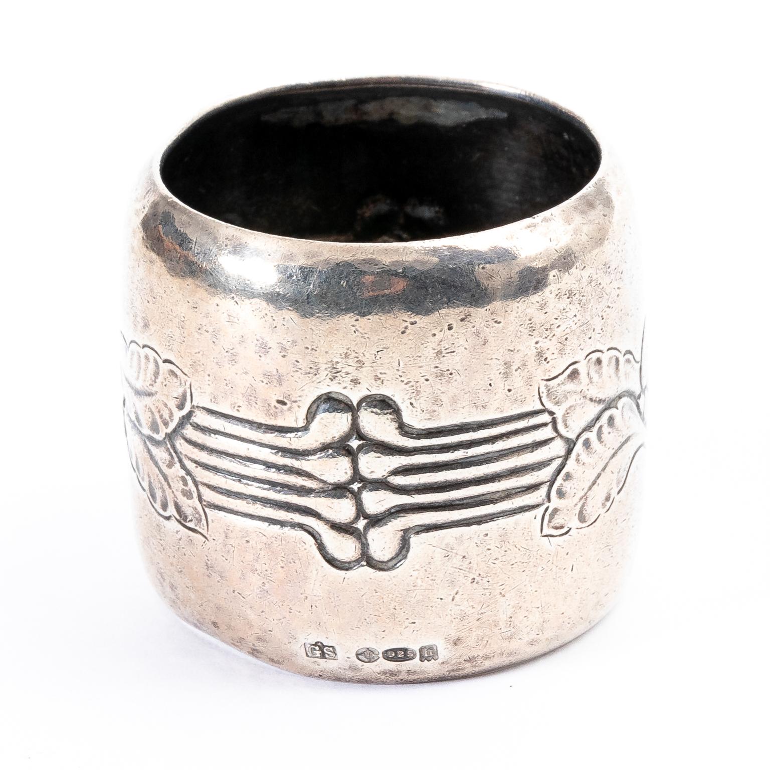 Sterling silver napkin ring designed and hammered by Georg Jensen with floral designs, circa 1920s. It was imported to England and made in Denmark. The piece features hallmark for early Jensen, 