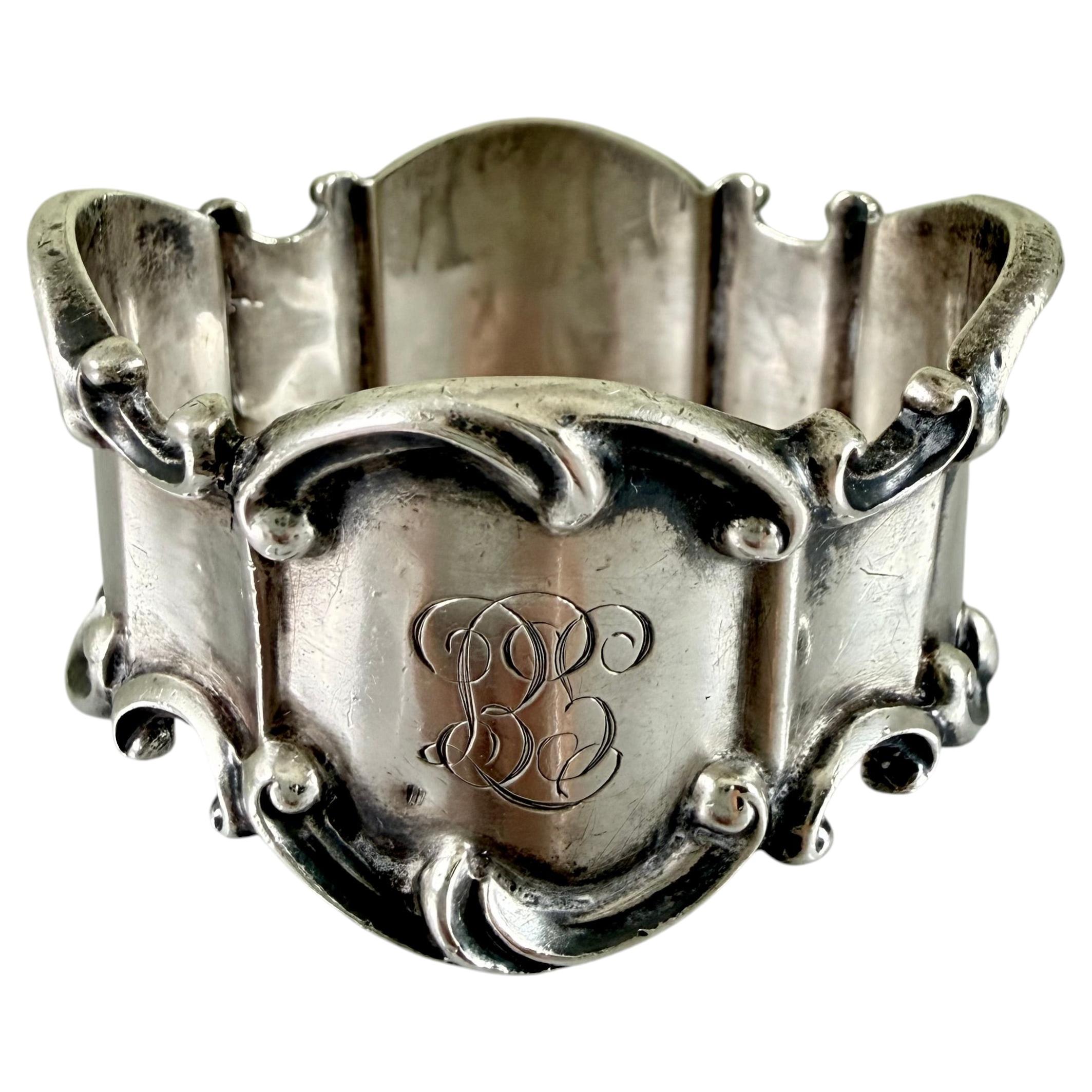 Anillo de servilleta antiguo de plata de ley, de forma ovalada con volutas, con iniciales grabadas