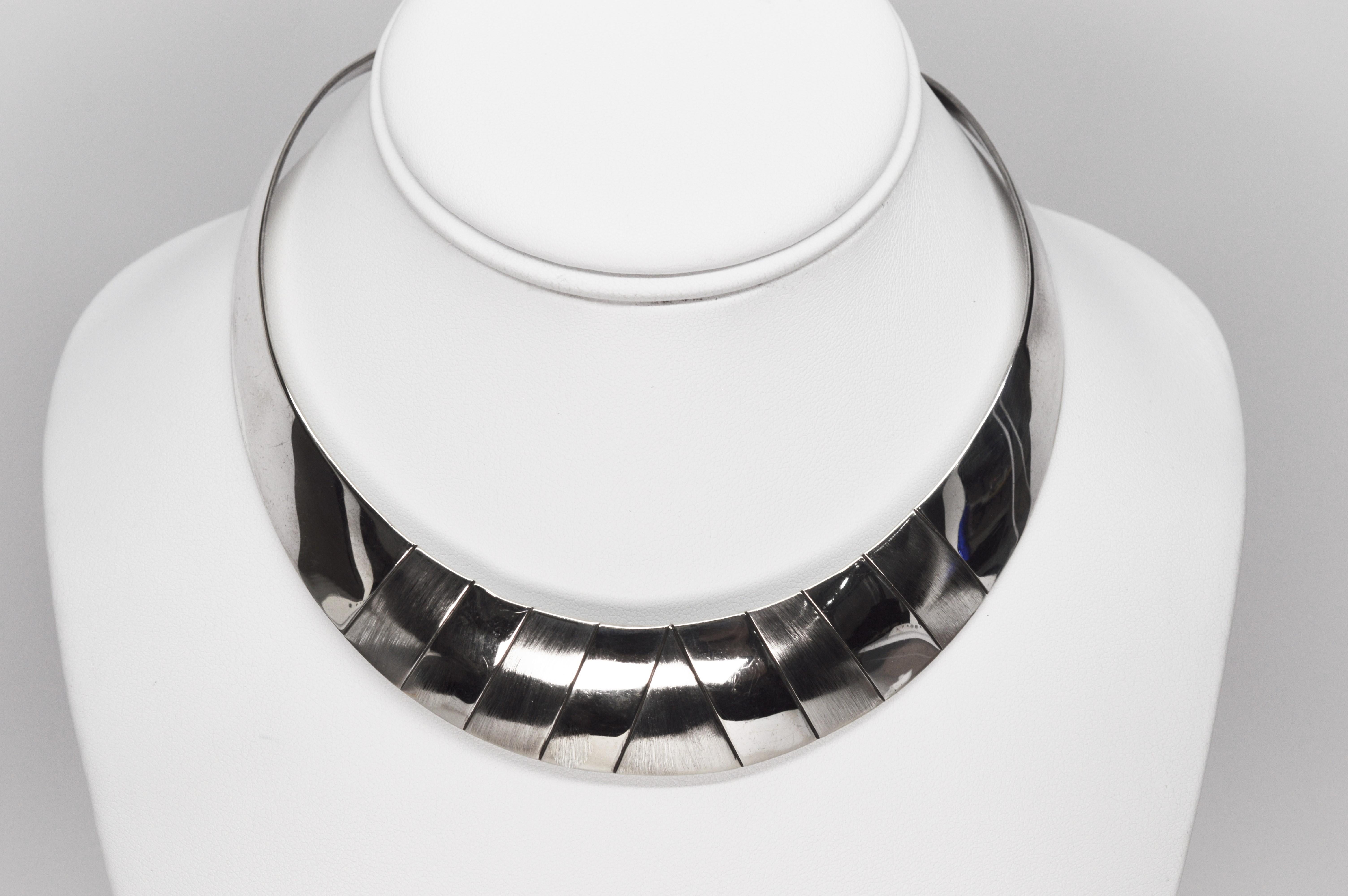 Add this fun, chic piece to your collection. In polished sterling silver, the collar necklace is graduated to the front and accented with brush sterling tiles that give depth and dimension to the structured sleek look of the neck cuff choker style