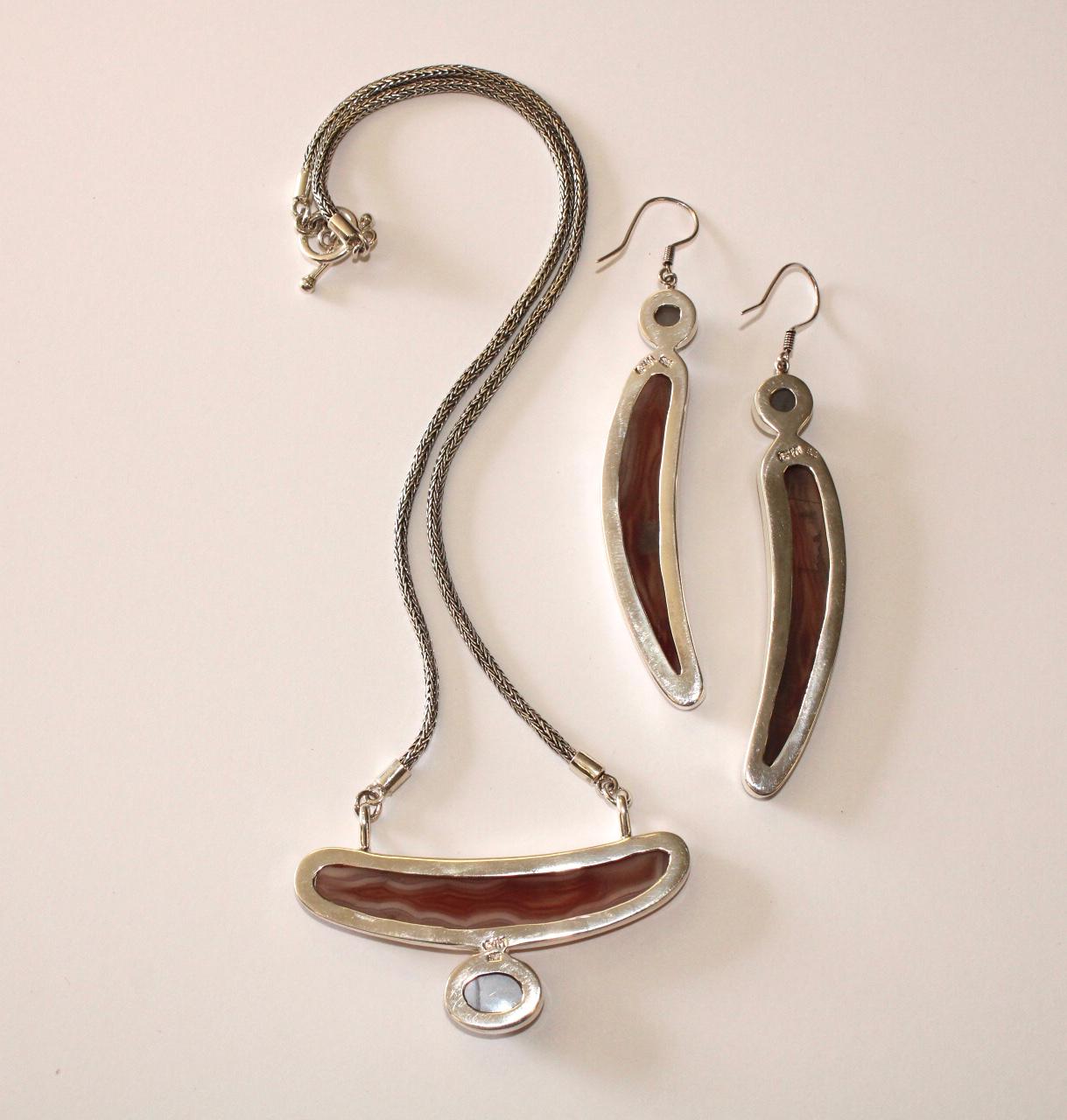 We collaborate with a master silversmith in Kotagede, Java, the heart of the silver industry in Indonesia to create these one of kind pieces.  This dramatic set features a rare pink translucent banded agate with a moonstone accent stone. 
