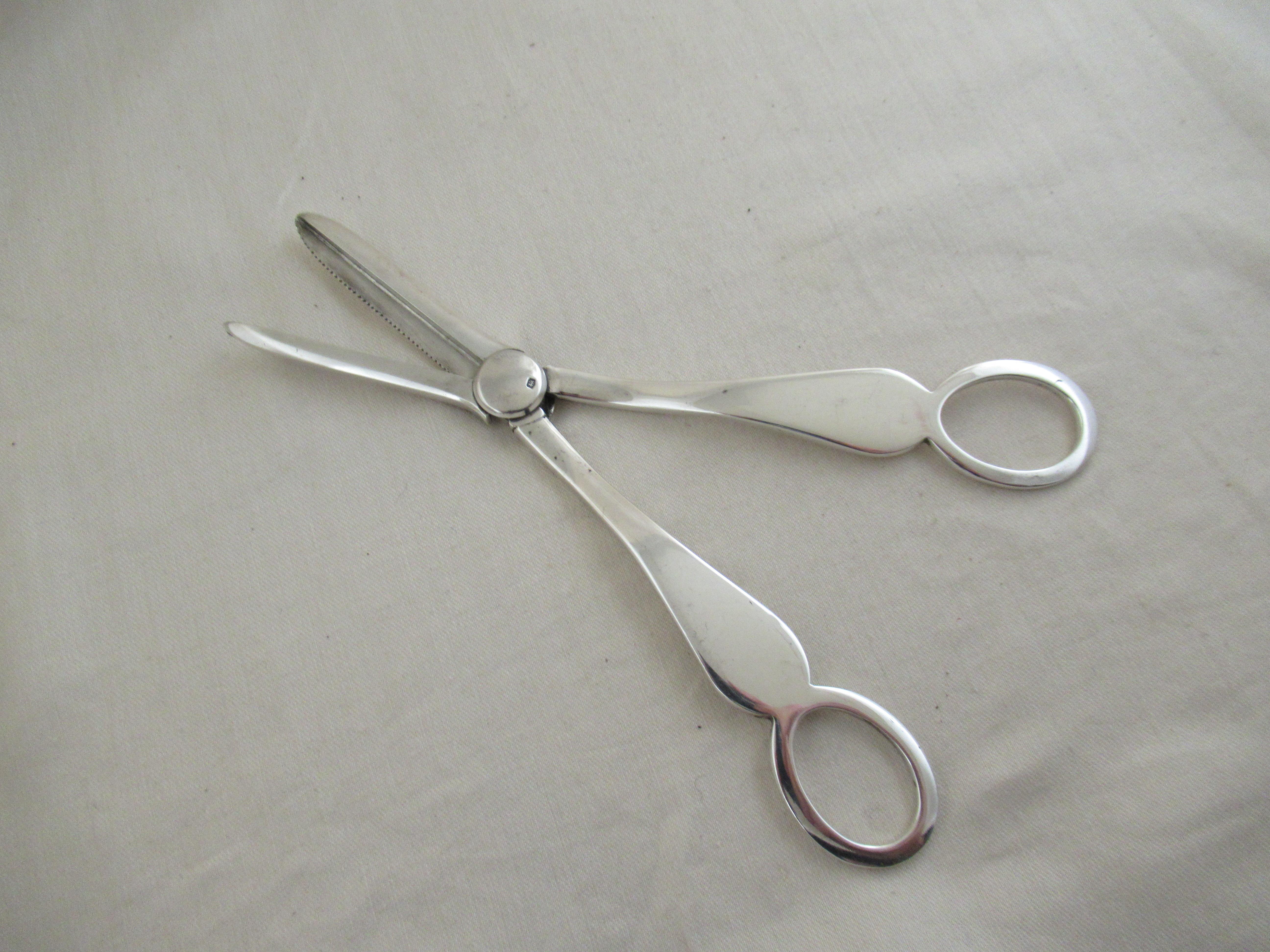 A superb pair of Grape Scissors or shears, made in the most sought after Old English pattern.
Used to cut a bunch of grapes from the vine, but also to grip the cut stem so that the bunch can be lifted down, carefully.. Make sure the top side of the