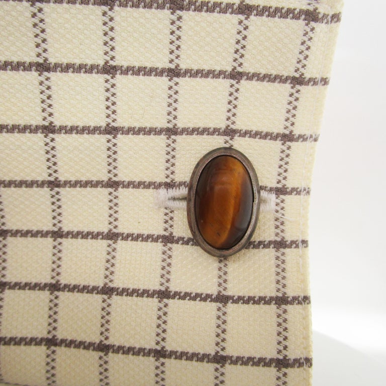 These are an incredible pair of vintage sterling silver cufflinks with gorgeous cat’s eye tiger’s eye centers. The tiger’s eye has a beautiful orientation- it’s winking eyes trace a horizontal line down the length of the oval cufflinks, dividing the