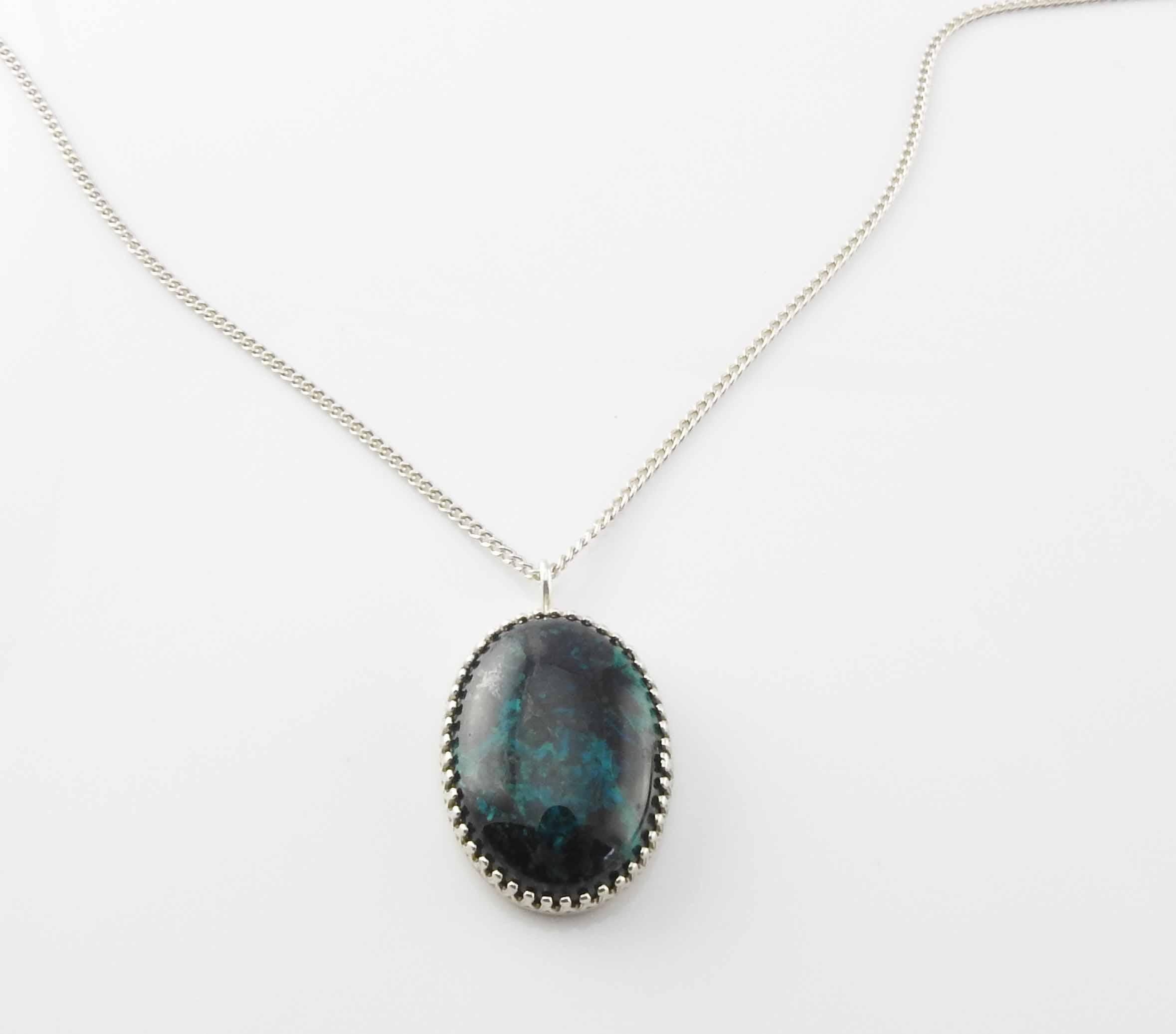 Sterling silver oval shaped chrysocolla pendant.

Marked: pendant: STERLING.  Chain: CACO STG, Sterling on clasp

Measures: 18 1/4