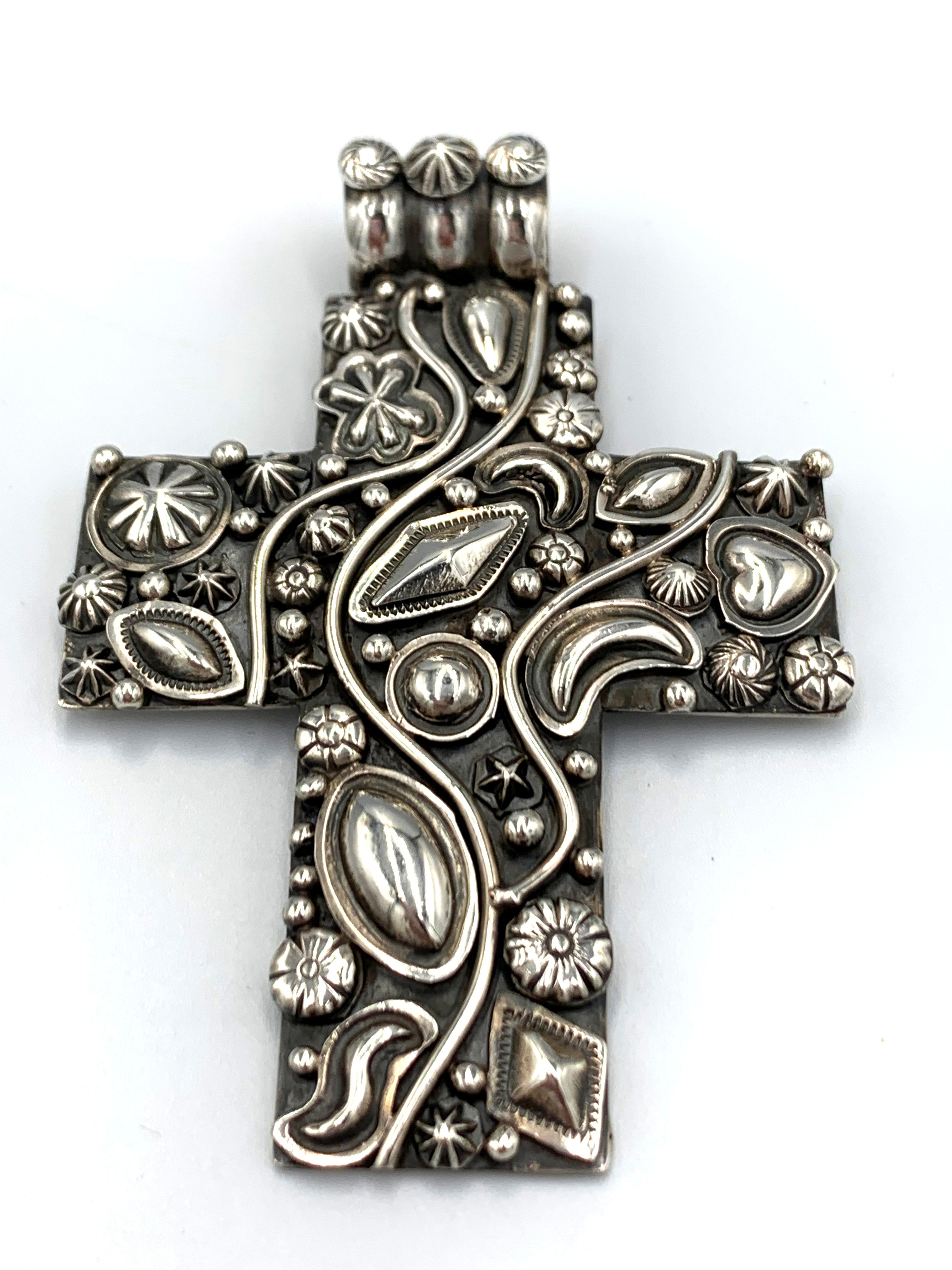 Questo ciondolo a forma di croce sovrapposta in argento sterling è realizzato dall'argentiere Navajo Ronnie Willie. Misura 2½