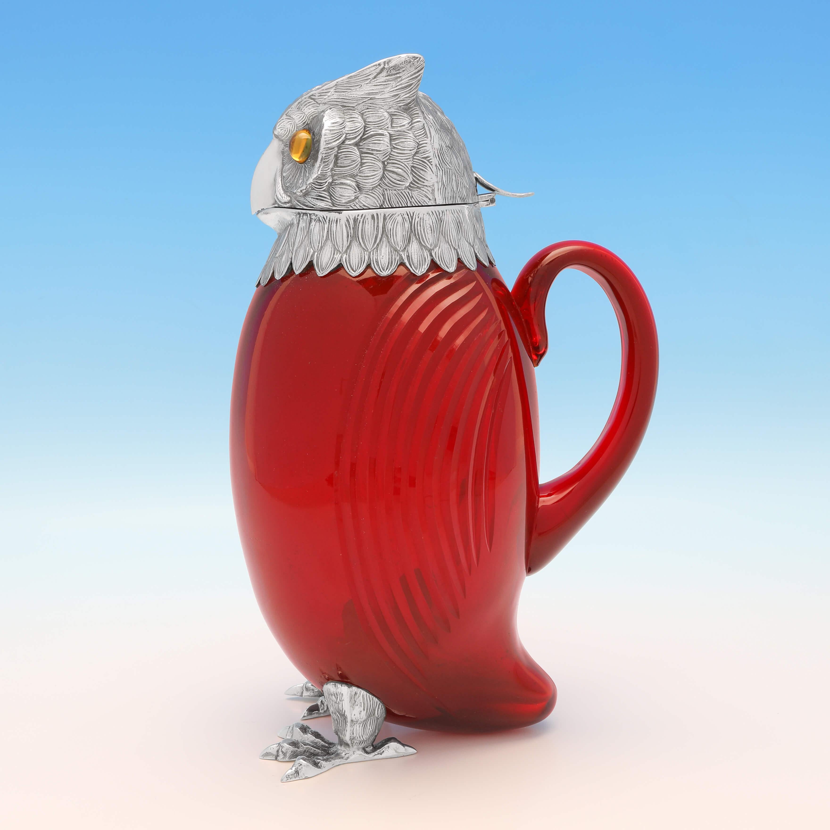 Carrying import marks for London in 1972 by I. Freeman & Sons, this highly unusual, Elizabeth II, sterling silver claret jug, is modelled to look like an owl, with a red glass body and amber colored eyes. The claret jug measures 11