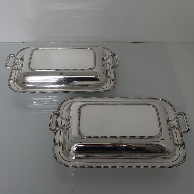 A very stylish pair of plain-formed side handled gadroon entrée dishes with single crests. The lids of the entrée dishes are detachable with gadroon on the underside so that they can be used either as pair or four separate serving dishes when one