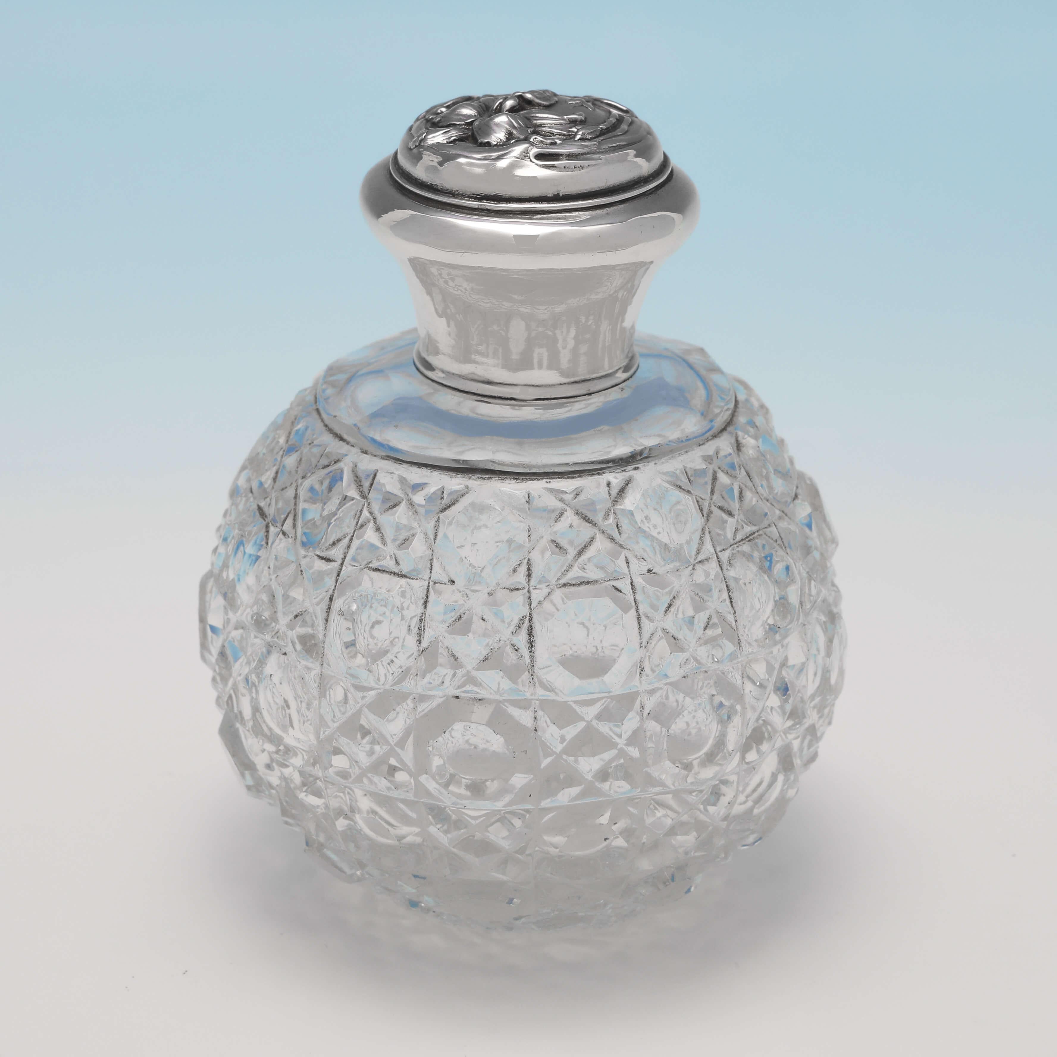 Hallmarked in Birmingham in 1908 by Thomas Bishton, this attractive pair of Edwardian, Antique Sterling Silver Scent Bottles, features hobnail cut glass bodies, and art nouveau design silver lids. Each scent bottle measures 3.75