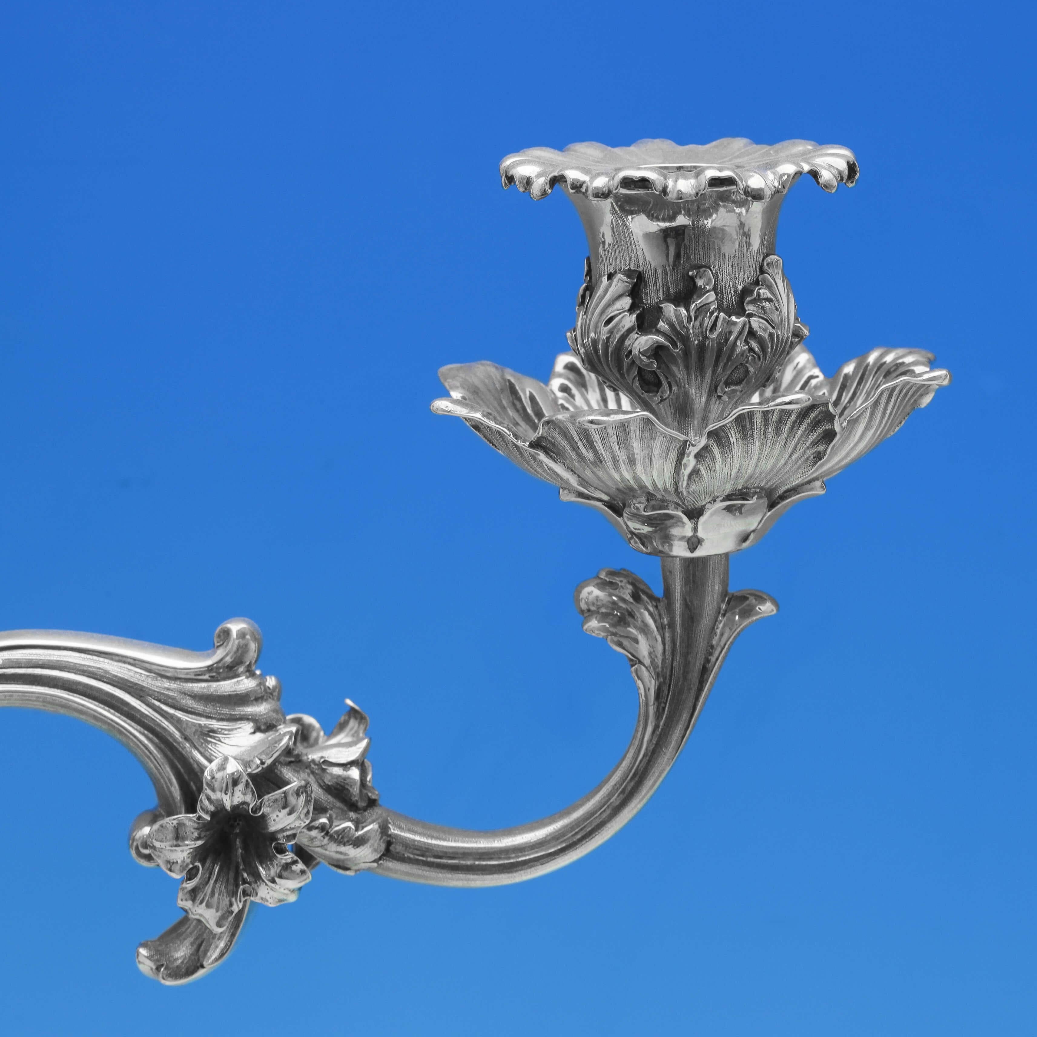 Marcado en Londres en 1870 por Robert Hennell IV (con una rama marcada por Robert Hennell III en 1840), este maravilloso par de candelabros antiguos de plata de ley es de magnífica calidad, con decoración rococó de roleos, acantos y flores, y