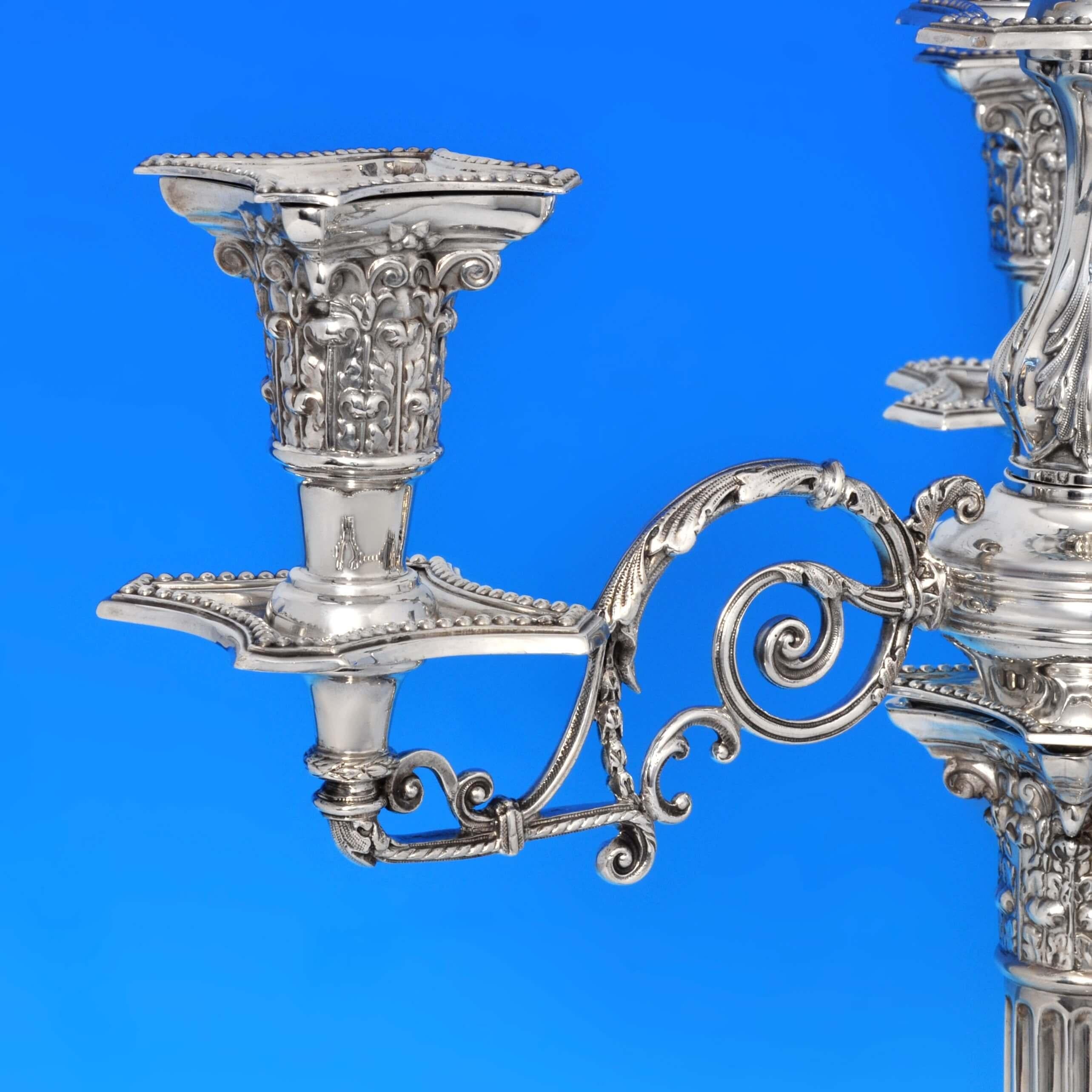 Hallmarked in London in 1901 by C. C. Pilling, this attractive pair of late Victorian, Antique, Sterling Silver Candelabra are in the Corinthian column style featuring bead borders, stepped bases, fluted columns, corinthian capitals, and four light
