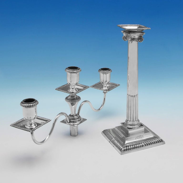 Hallmarked in London, 1763 by James Waters, this striking, George III, antique, sterling silver pair of candelabra, feature Ionic design columns, gadroon borders, and square drip pans. Each candelabra measures 16.75 inches (42.5cm) tall, by 13.75