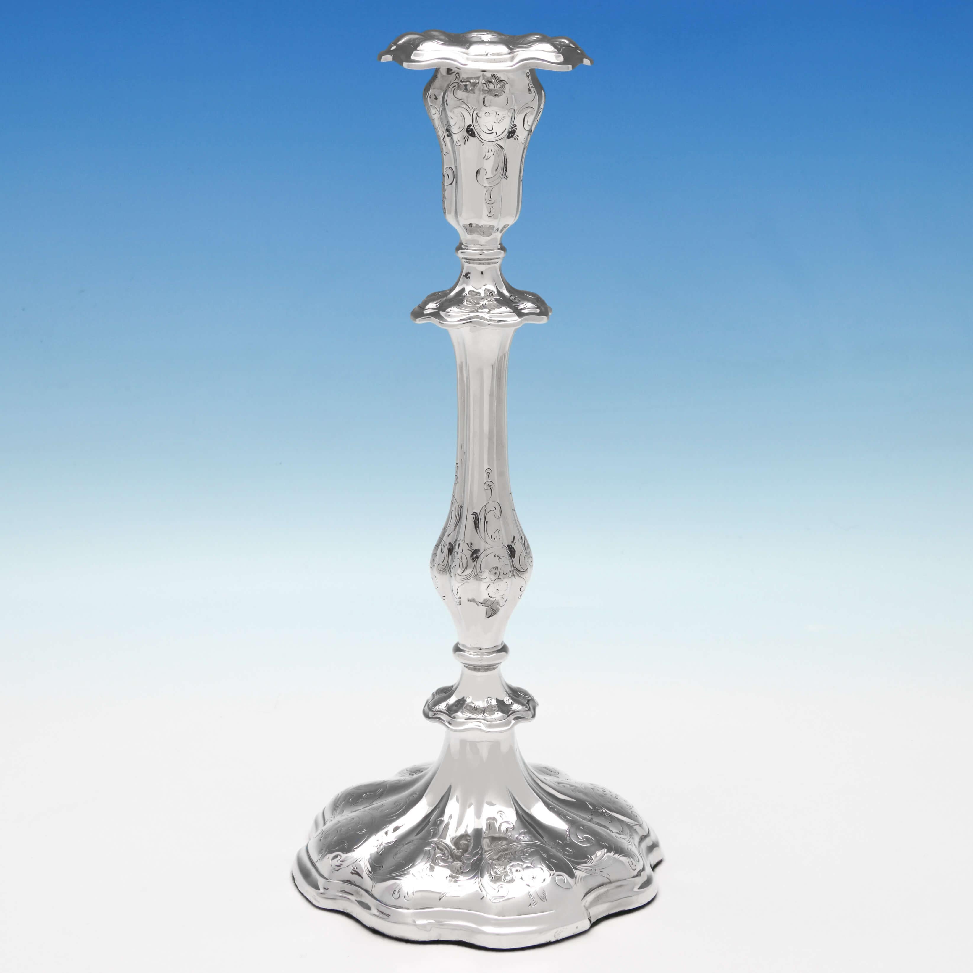 Hallmarked in Sheffield in 1846 by Waterhouse, Hatfield & Co., this attractive pair of antique, Victorian, sterling silver candlesticks have brightcut engraved decoration on the shaped baluster columns and bases. Each candlesticks measures 11