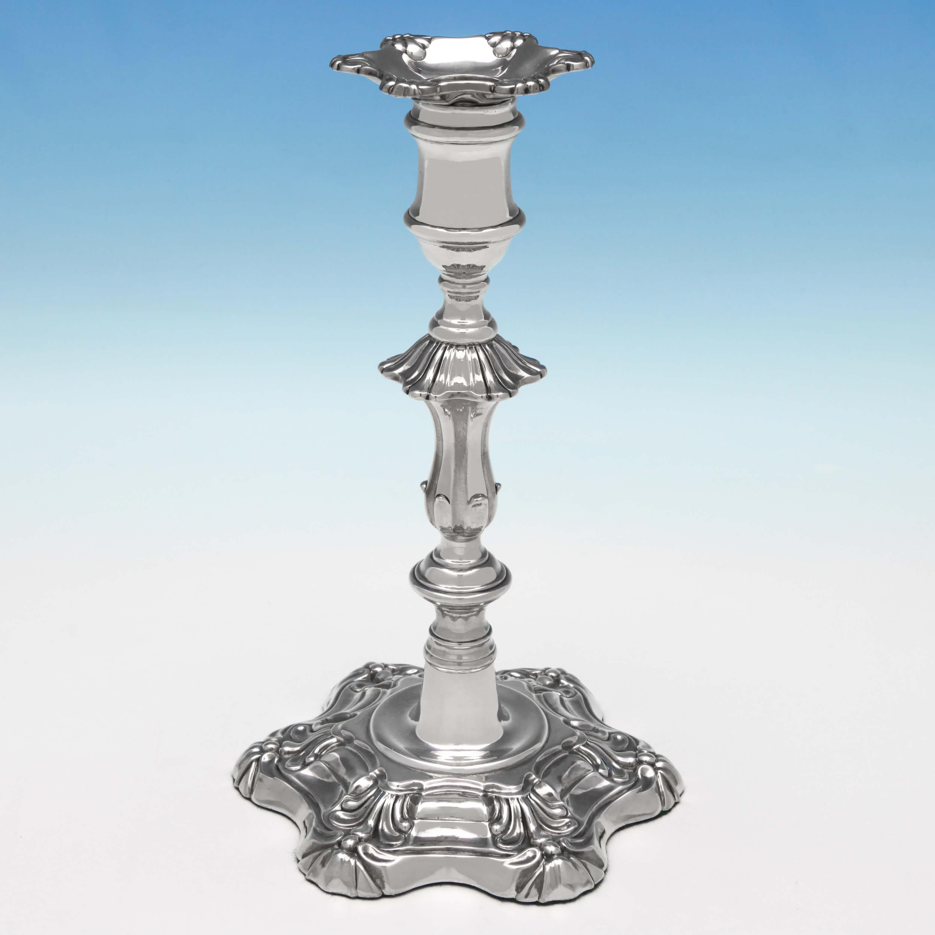 Hallmarked in Sheffield in 1828 by Kirkby Waterhouse & Co., this attractive, George IV, Antique, sterling silver pair of candlesticks, are in the 'Six Shell' style, and feature removable sconces and engraved crests. Each candlestick measures 9