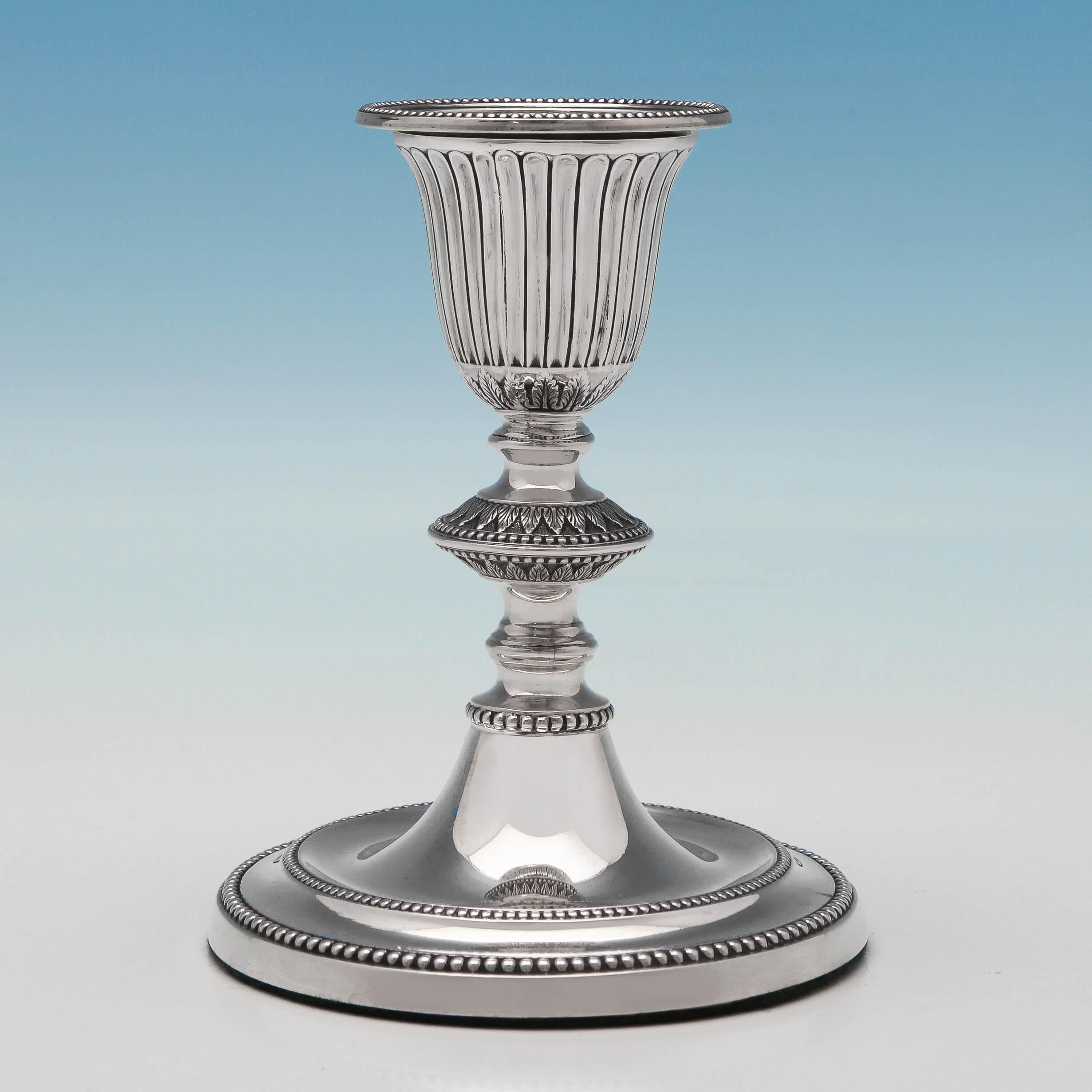 Hallmarked in Sheffield in 1886 by James Kebberling Bembridge, this attractive pair of Victorian antique, sterling silver candlesticks, feature bead borders, fluted decoration, acanthus detailing, and removable sconces. Each candlestick measures