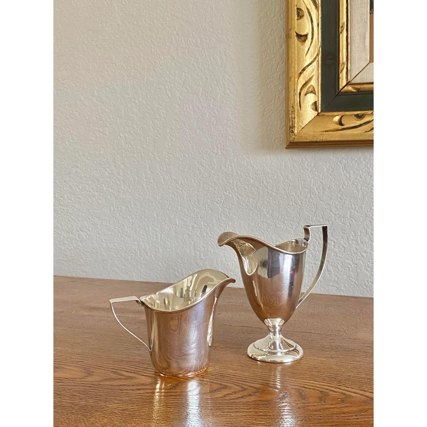 Un set di due lattiere in argento sterling coordinate in stile neoclassico. Splendide forme che sarebbero perfette per un semplice sciroppo o per i piattini di un vassoio da tè o di un servizio da caffè; uno potrebbe contenere uno sciroppo di