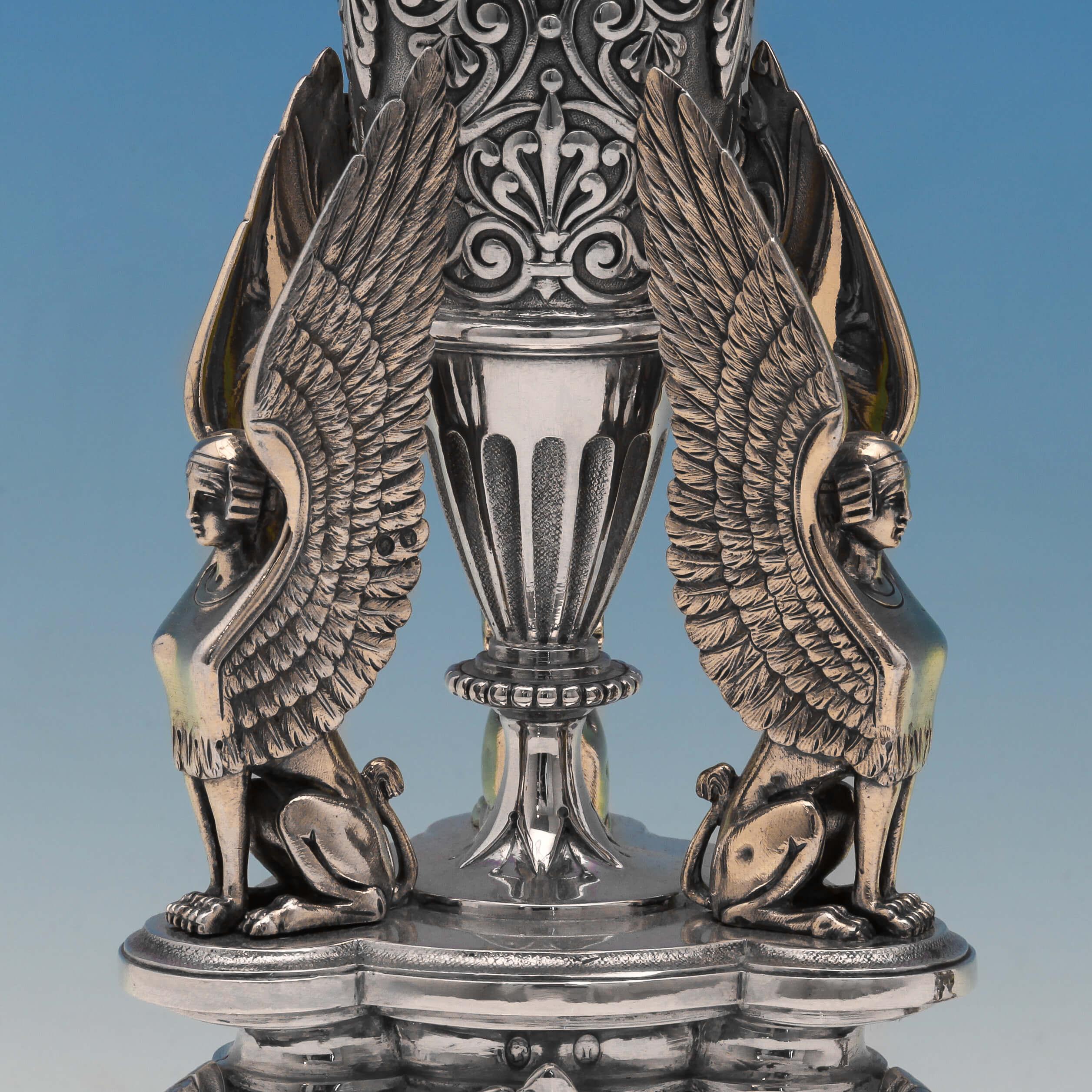 Hallmarked in Birmingham in 1873 by Elkington & Co., this superb pair of antique, Victorian, sterling silver dessert stands are in the Egyptian revival style. Three gilt figures of a Sphinx appear to hold up the central urn shaped column, which