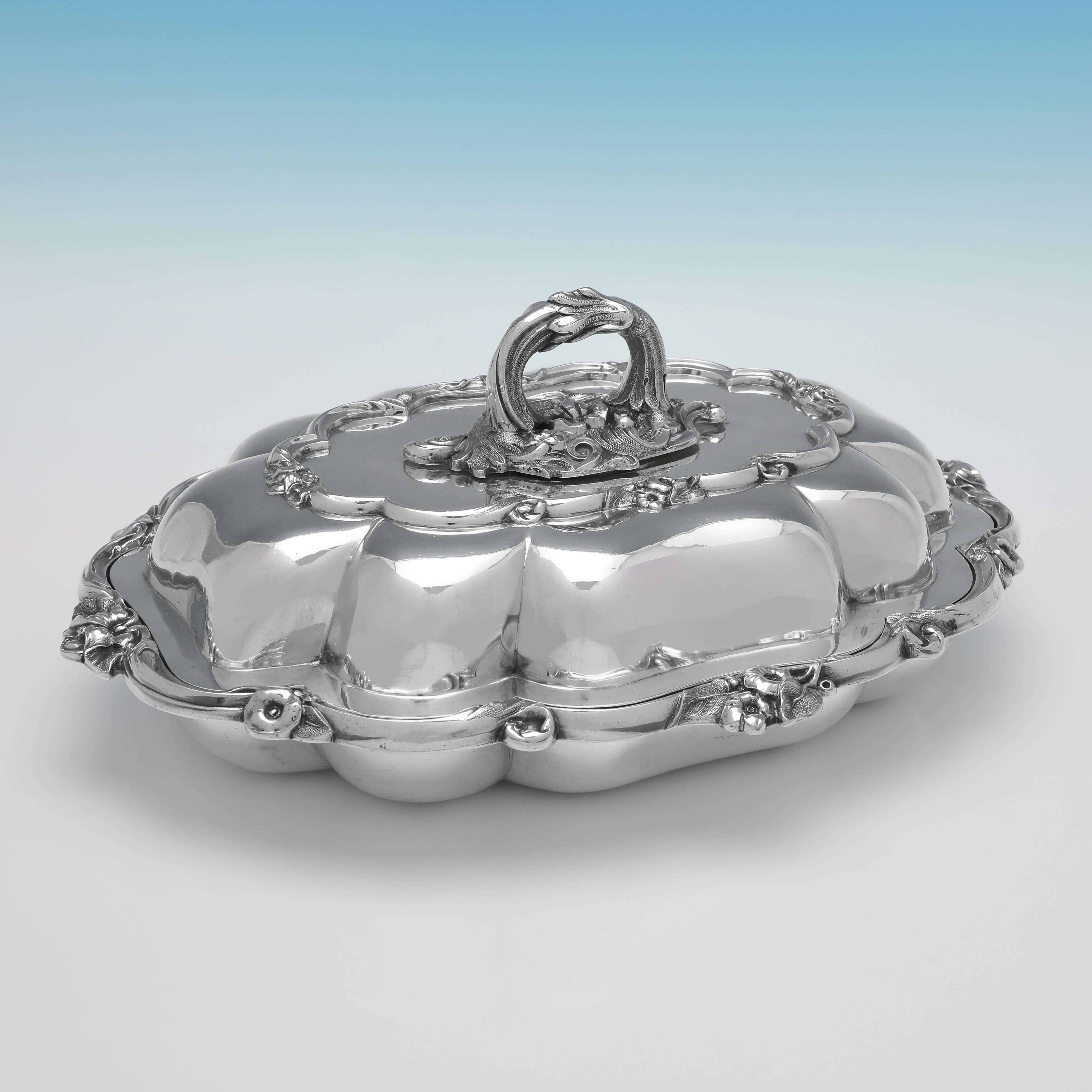 Hallmarked in London in 1841 by Joseph Angell & Son, this ornate pair of Victorian, Antique Sterling Silver Entree Dishes, feature shaped borders, with floral and scroll decoration, and removable handles. Each entree dish measures 5.5
