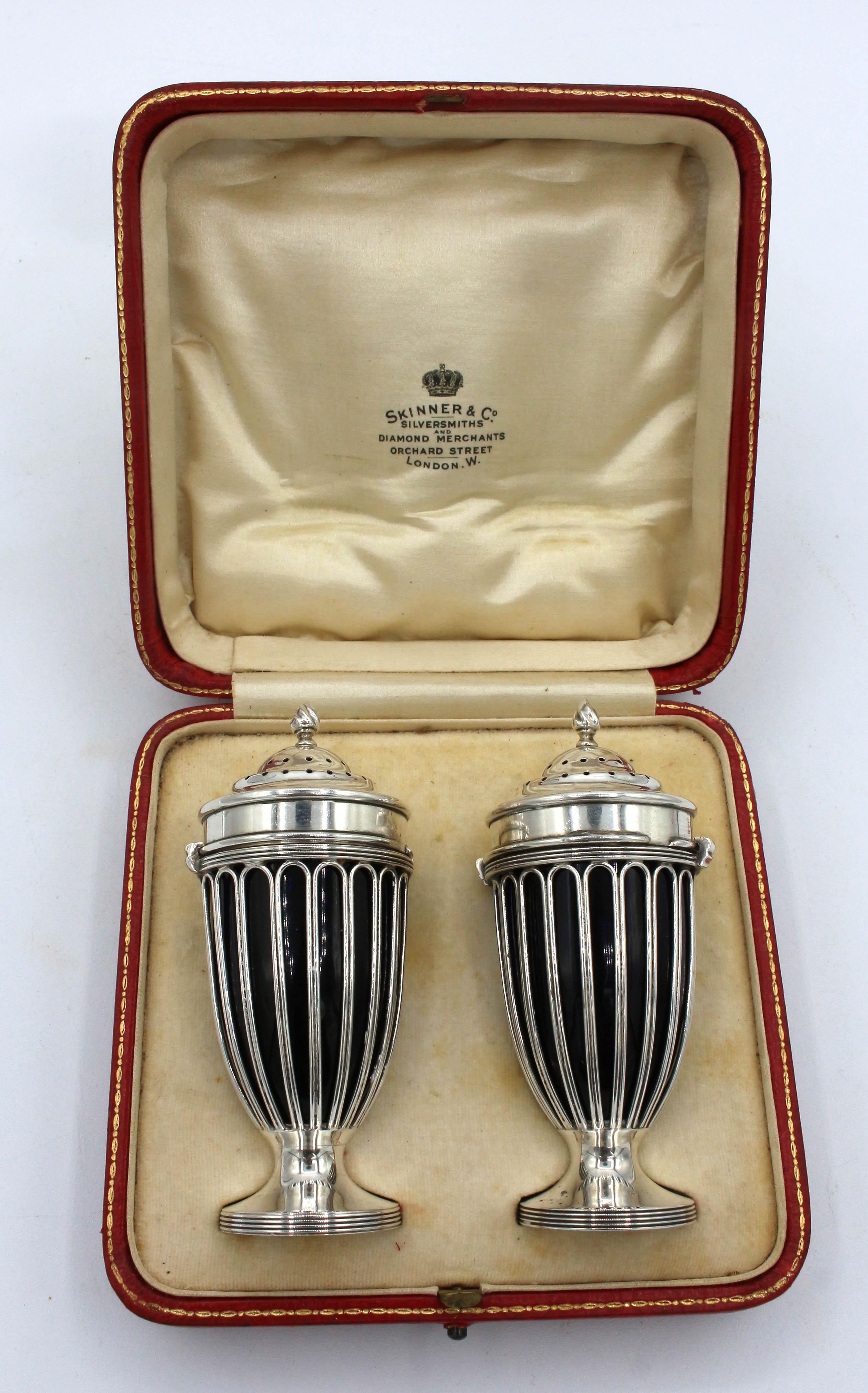 London, 1910, sterling silver pair of salt & pepper casters. Cobalt glass lined. Neoclassical taste with twist flame finials. Made by Edward John Haseler & Noble Haseler. Original scarlet & gilt, satin lined case for presentation from Skinner & Co,