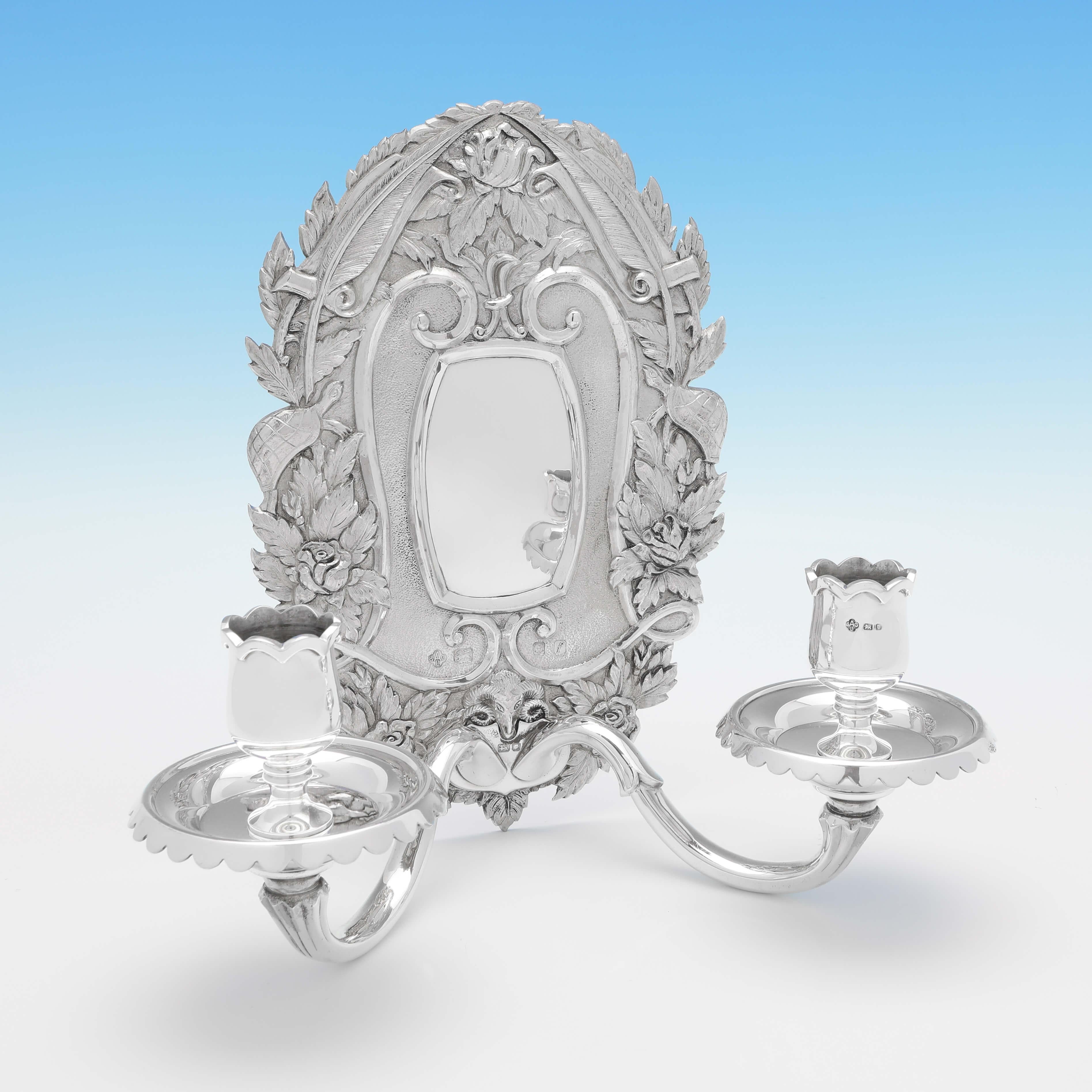 Hallmarked in London in 1961 by Asprey & Co. Ltd., this striking pair of Sterling Silver Wall Sconces, are in the Italian Rococo style, highly decorative to the backs, and with space for 2 candles each. Each wall sconce measures 9.5