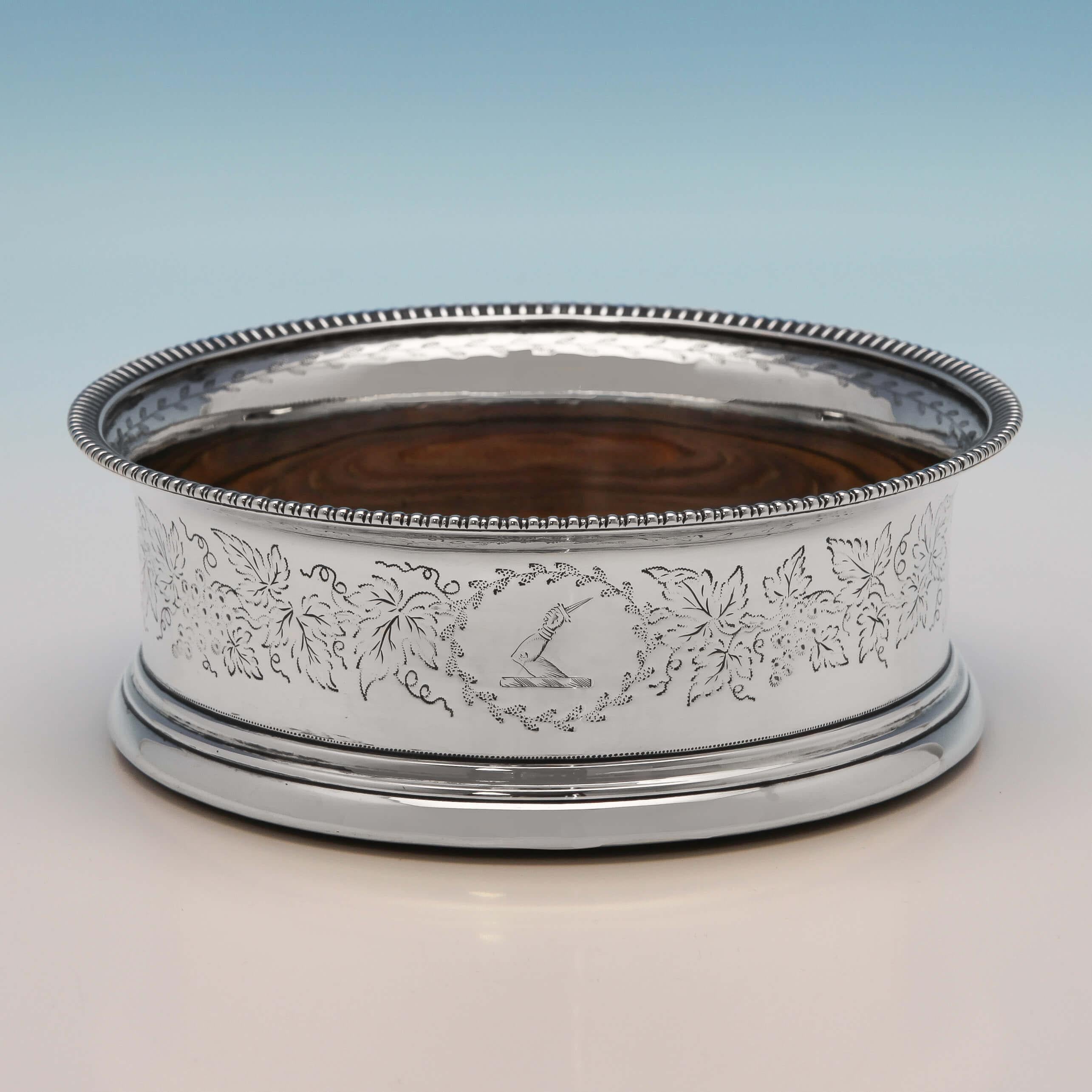 Hallmarked in London in 1804 by John Emes, this attractive pair of George III, Antique Sterling Silver Wine Coasters, feature engraved grape and vine decoration to the bodies, and gadroon borders. Each wine coaster measures 2