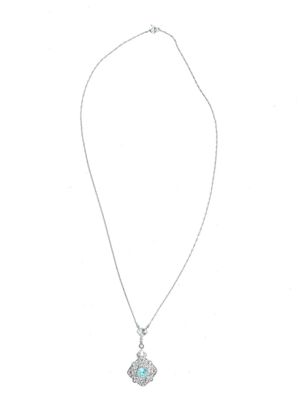 A sterling silver necklace with a pendant. The pendant has a diamond shape with a large round light blue stone in the center, surrounded by smaller cubic zirconia. Marked with sterling on the back side. Vintage Silver Jewelry Wares For